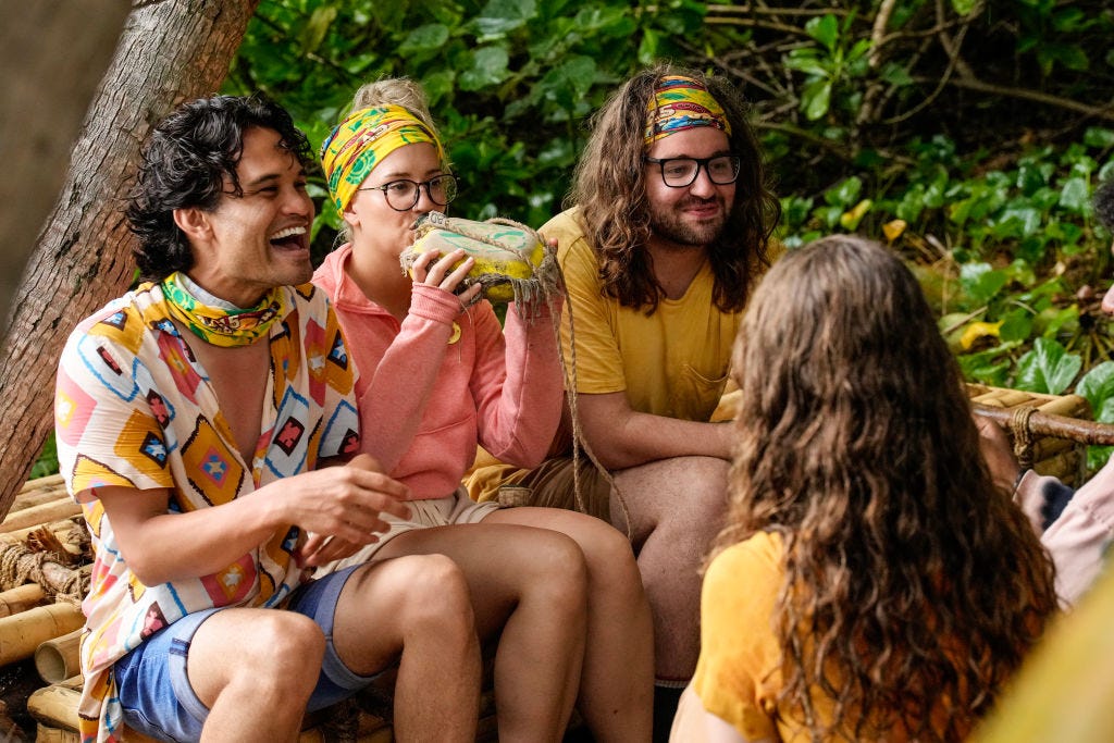 „Survivor“-Teilnehmer aus Staffel 45 sitzen auf einem Baumstamm und reden miteinander