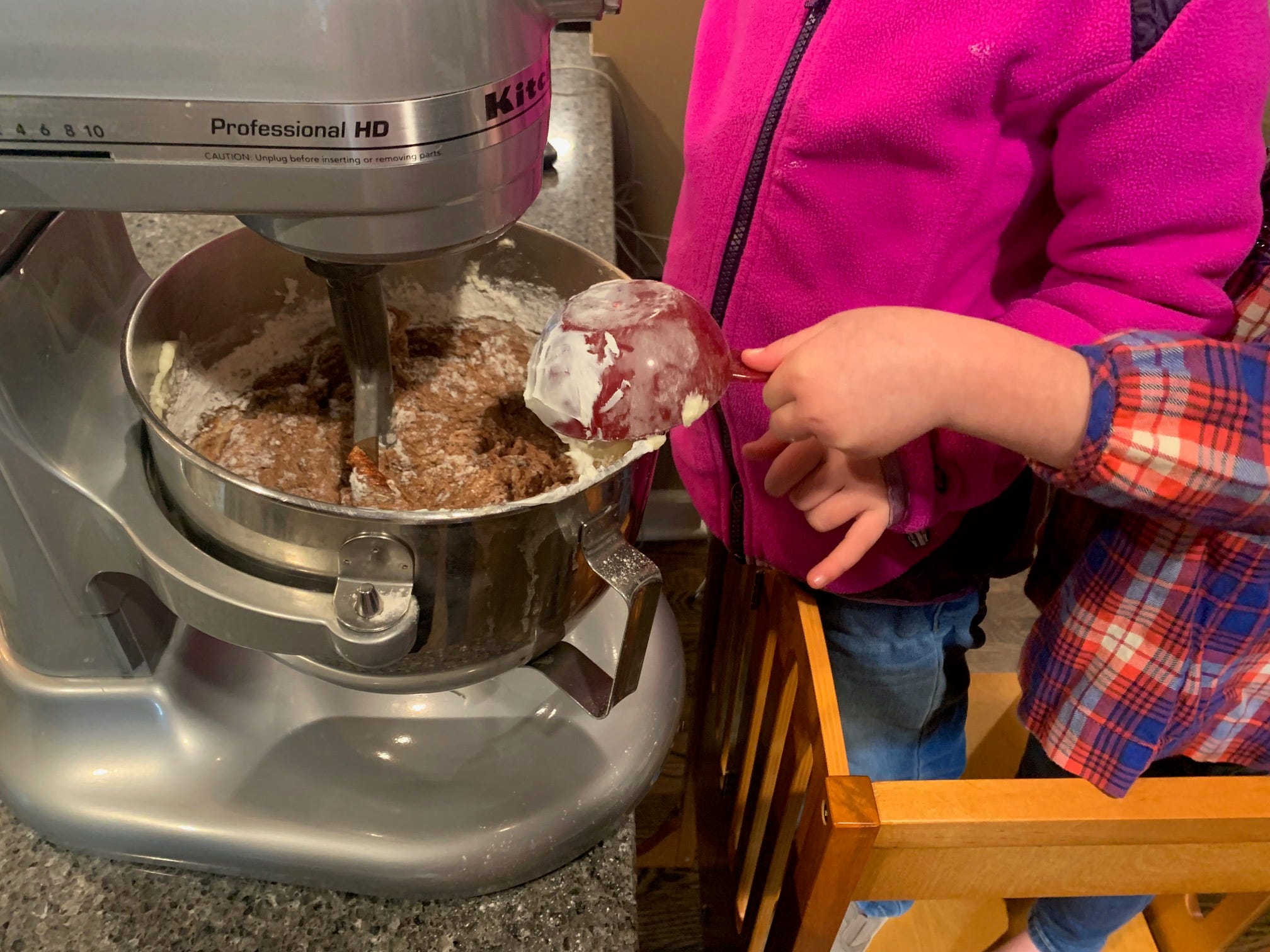 Emilys Kinder geben Zutaten für einen Kuchenteig in eine Küchenmaschine