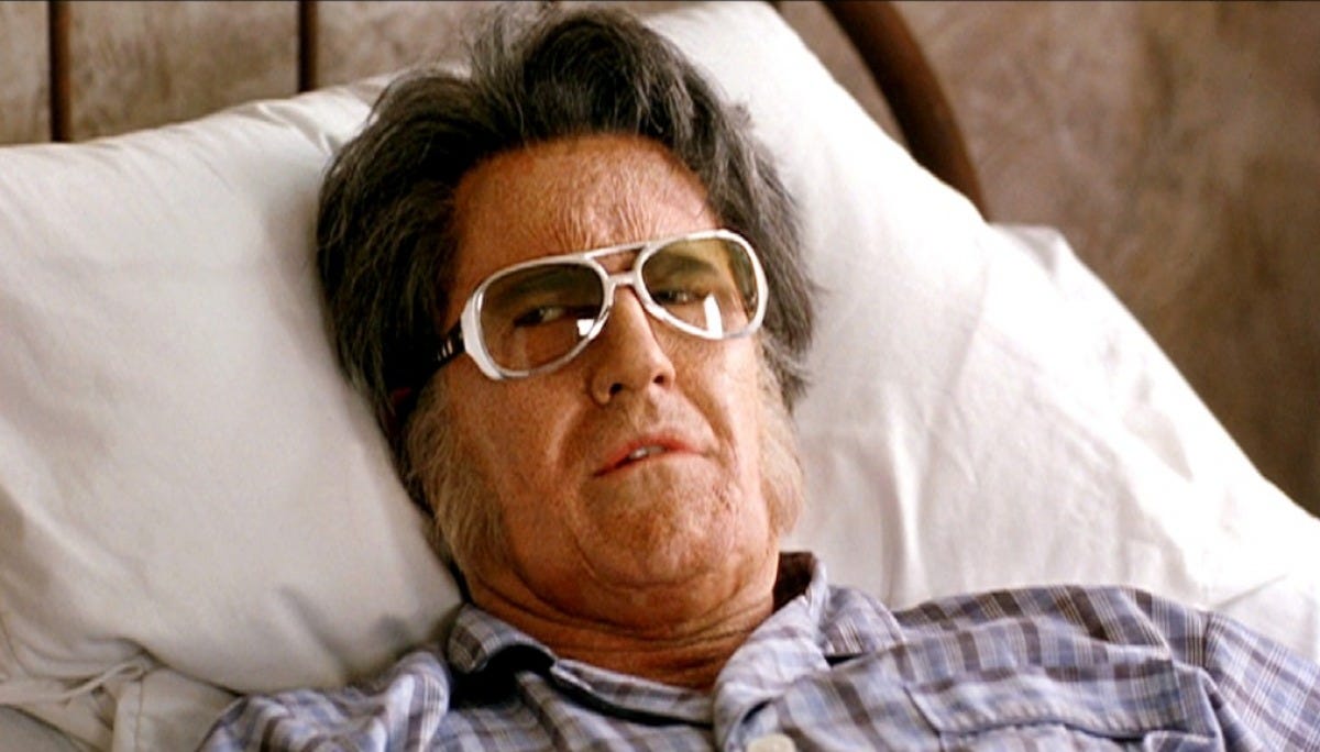 Bruce Campbell als Elvis Presley liegt auf einem Bett