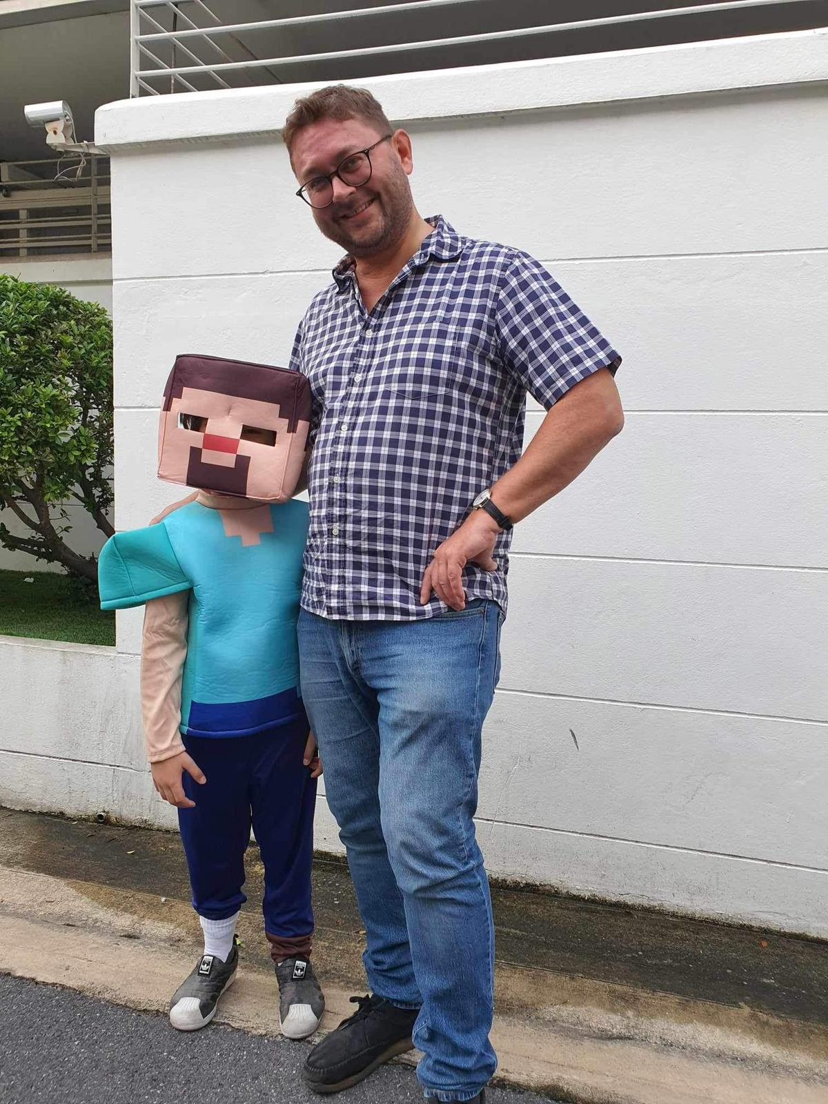 Vater und Sohn stehen zusammen;  Sohn trägt ein Minecraft-Kostüm.