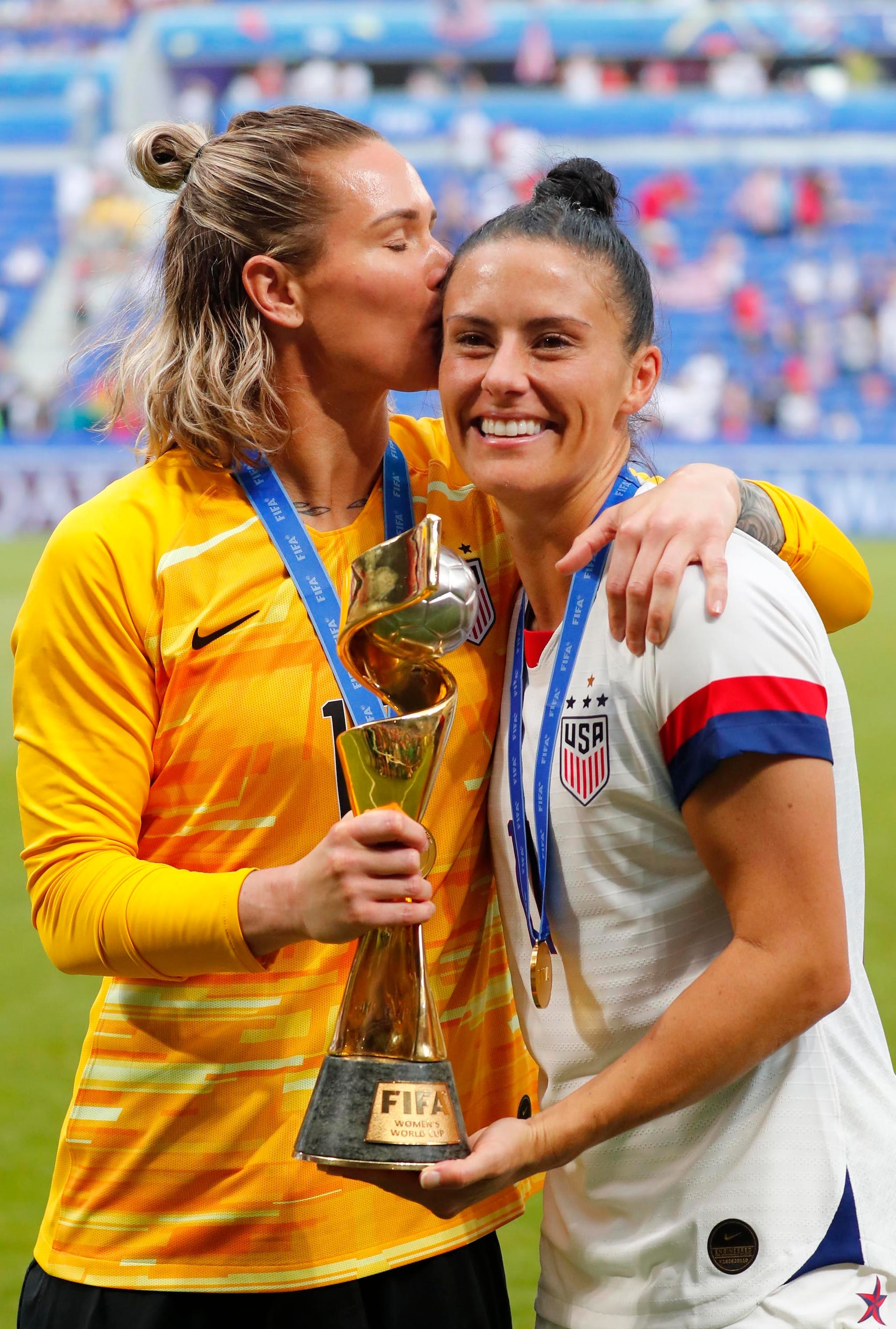 Ashlyn Harris (links) küsst Ali Krieger, während sie mit der WM-Trophäe 2019 posieren.