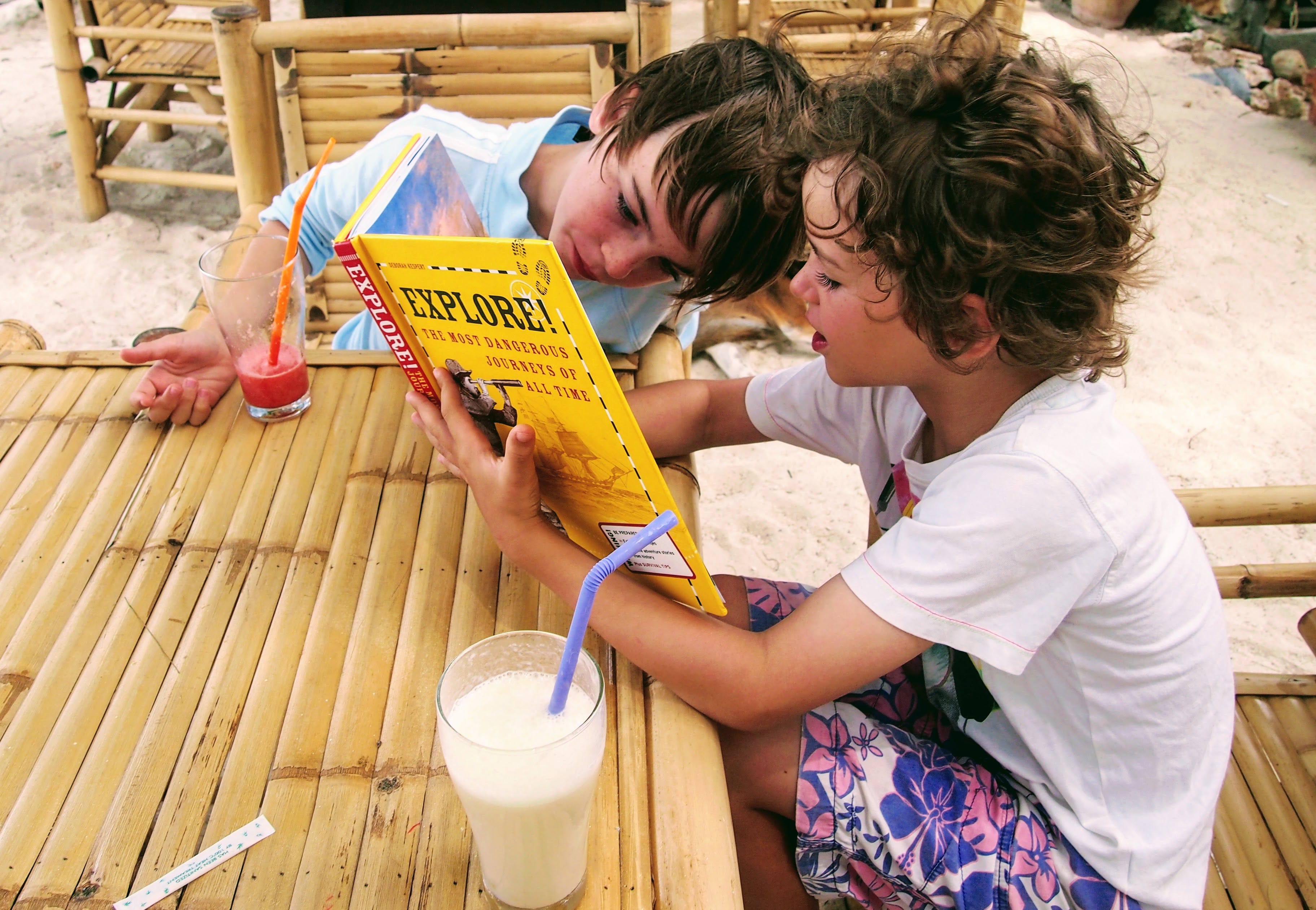 Longs Kinder lesen ein Buch mit gelbem Einband.