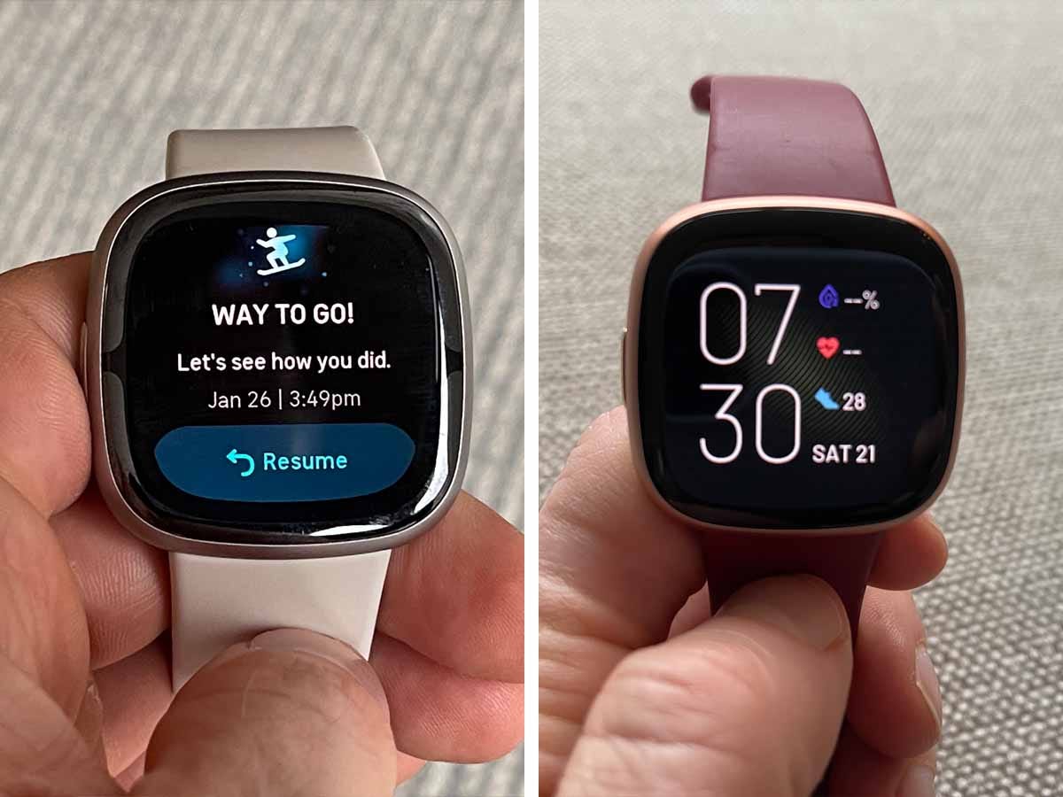 Nebeneinanderaufnahmen einer Fitbit Sense 2-Smartwatch und einer Fitbit Versa 4-Smartwatch, die in der Hand einer Person gehalten werden.