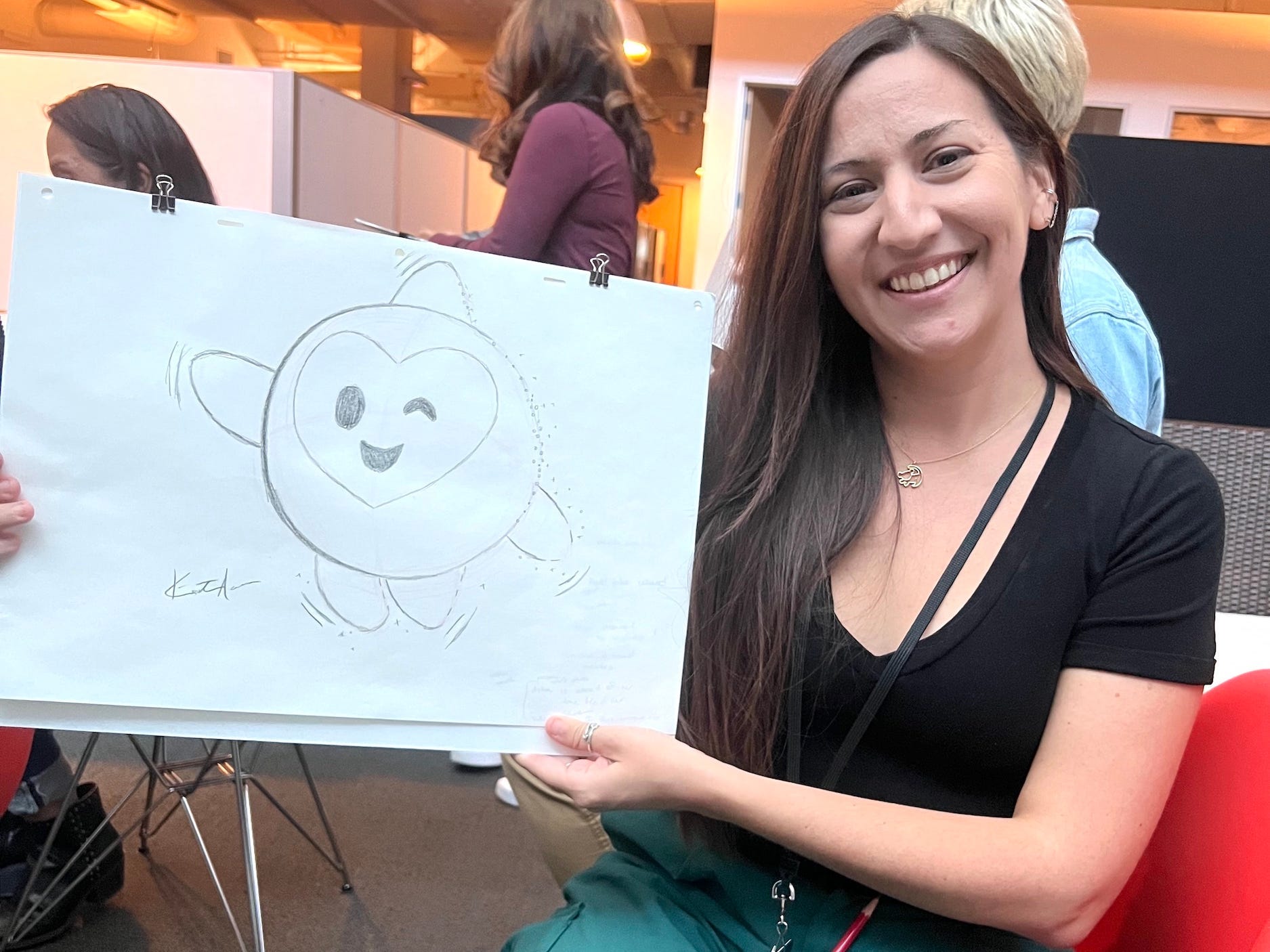Kirsten Acuna sitzt da und hält eine Zeichnung von Star aus „Wish“, die sie gezeichnet hat.