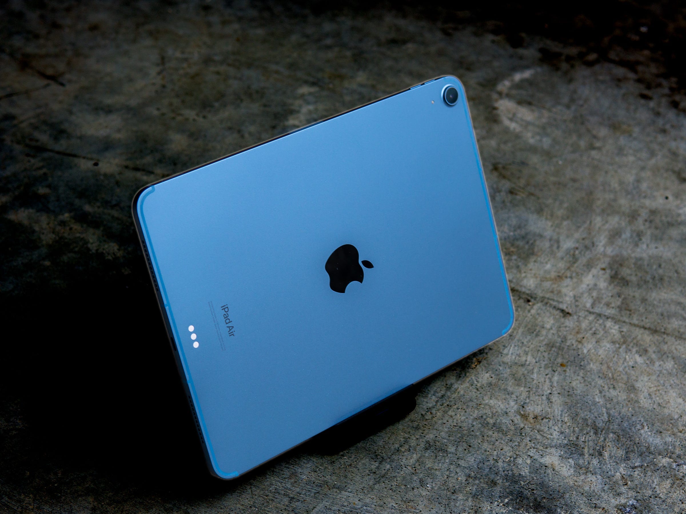 Die blaue Metallrückseite des iPad Air 2022 in einem dunkelgrauen Raum.