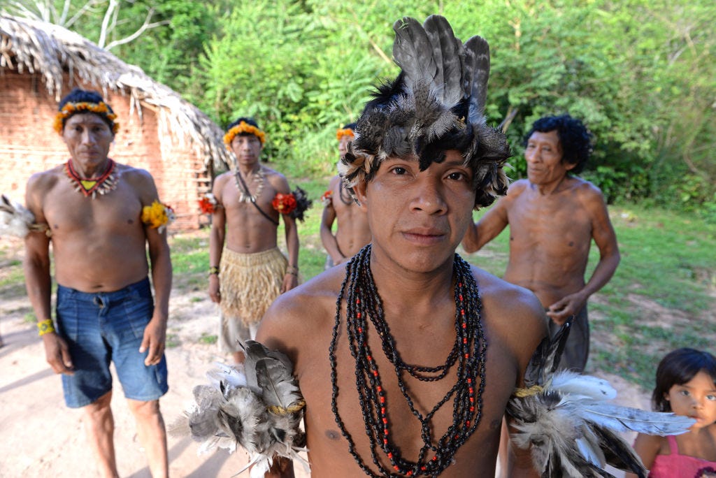 Ein junger Anführer des Awá-Stammes trägt in seinem Dorf Tiracambu, Maranhão, Brasilien, einen Kopfschmuck aus Truthahnfedern und andere Verzierungen.