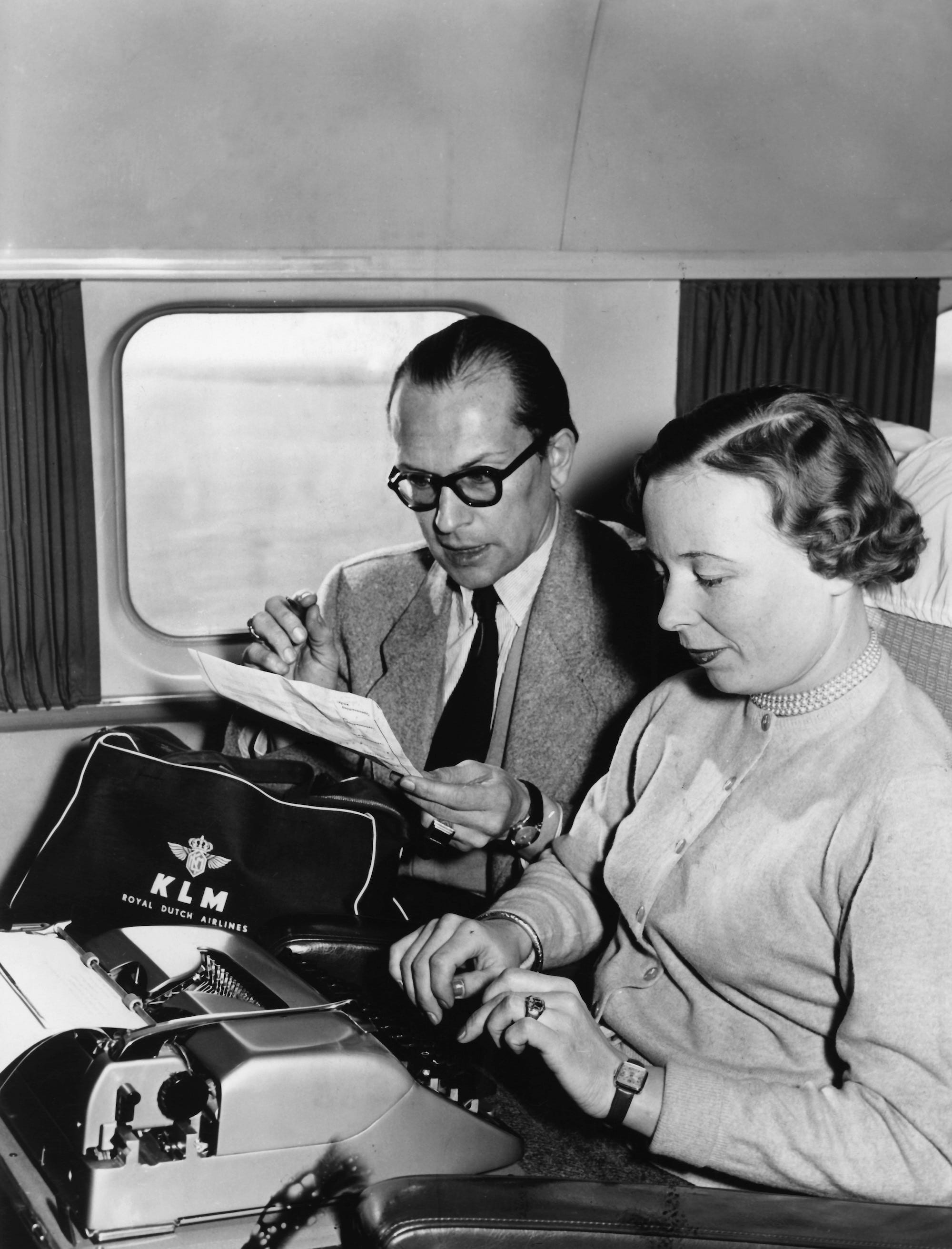 Eine Sekretärin tippt 1955 im Flugzeug auf einer Schreibmaschine