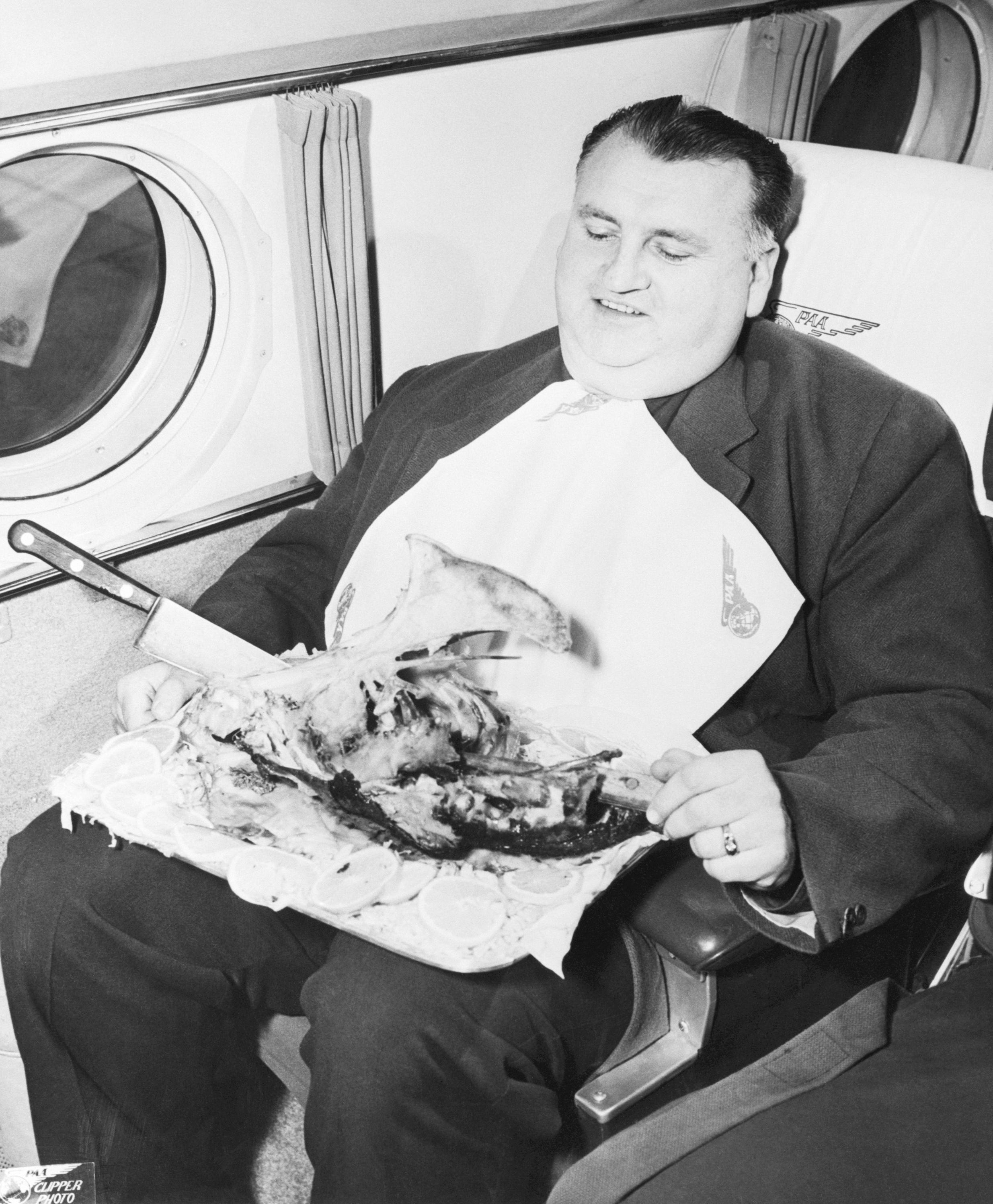 Ein Mann isst im Flugzeug einen Truthahn