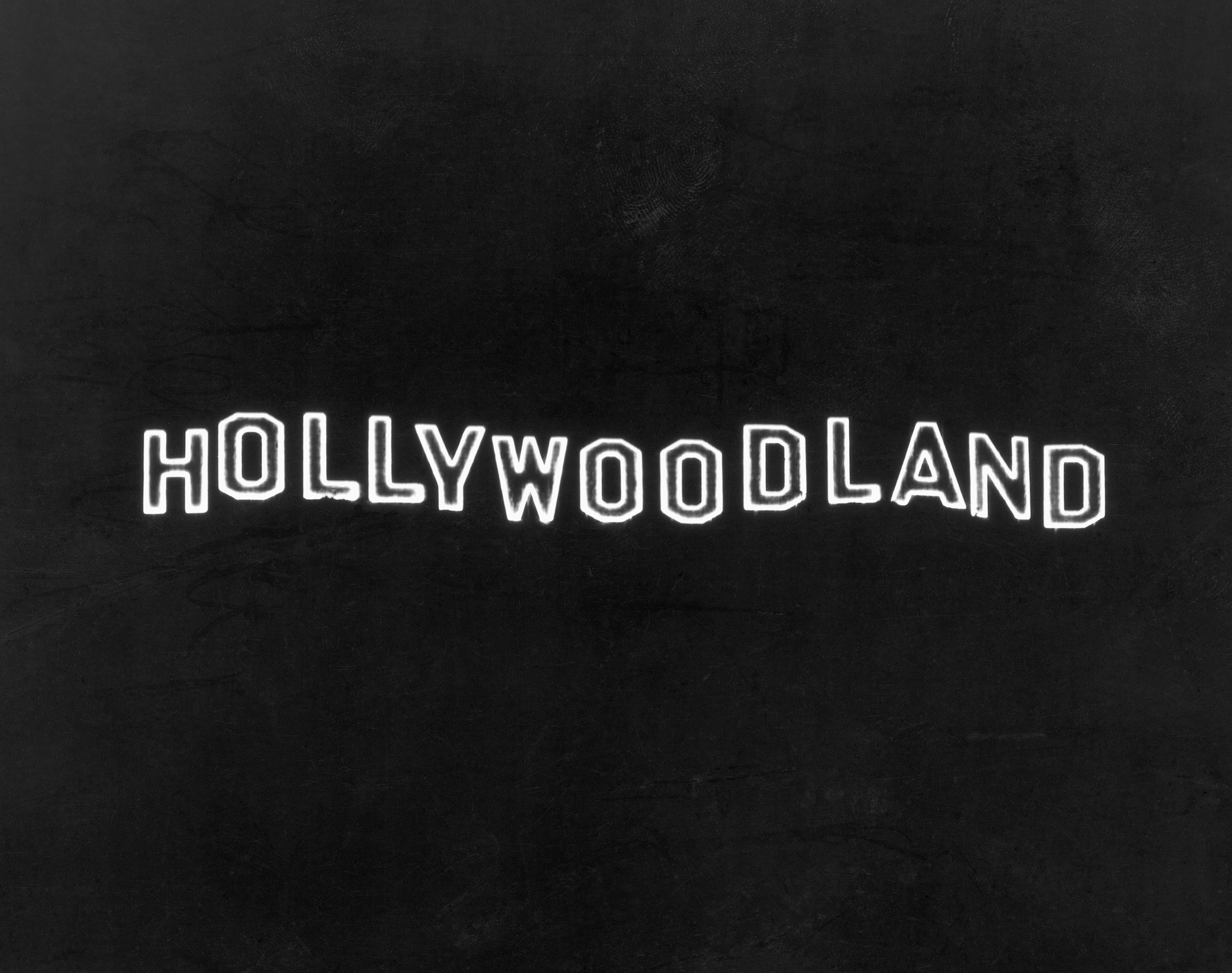 Das beleuchtete Hollywoodland-Schild bei Nacht auf dem Mount Lee in den Hollywood Hills mit Blick auf Hollywood in Los Angeles, Kalifornien.