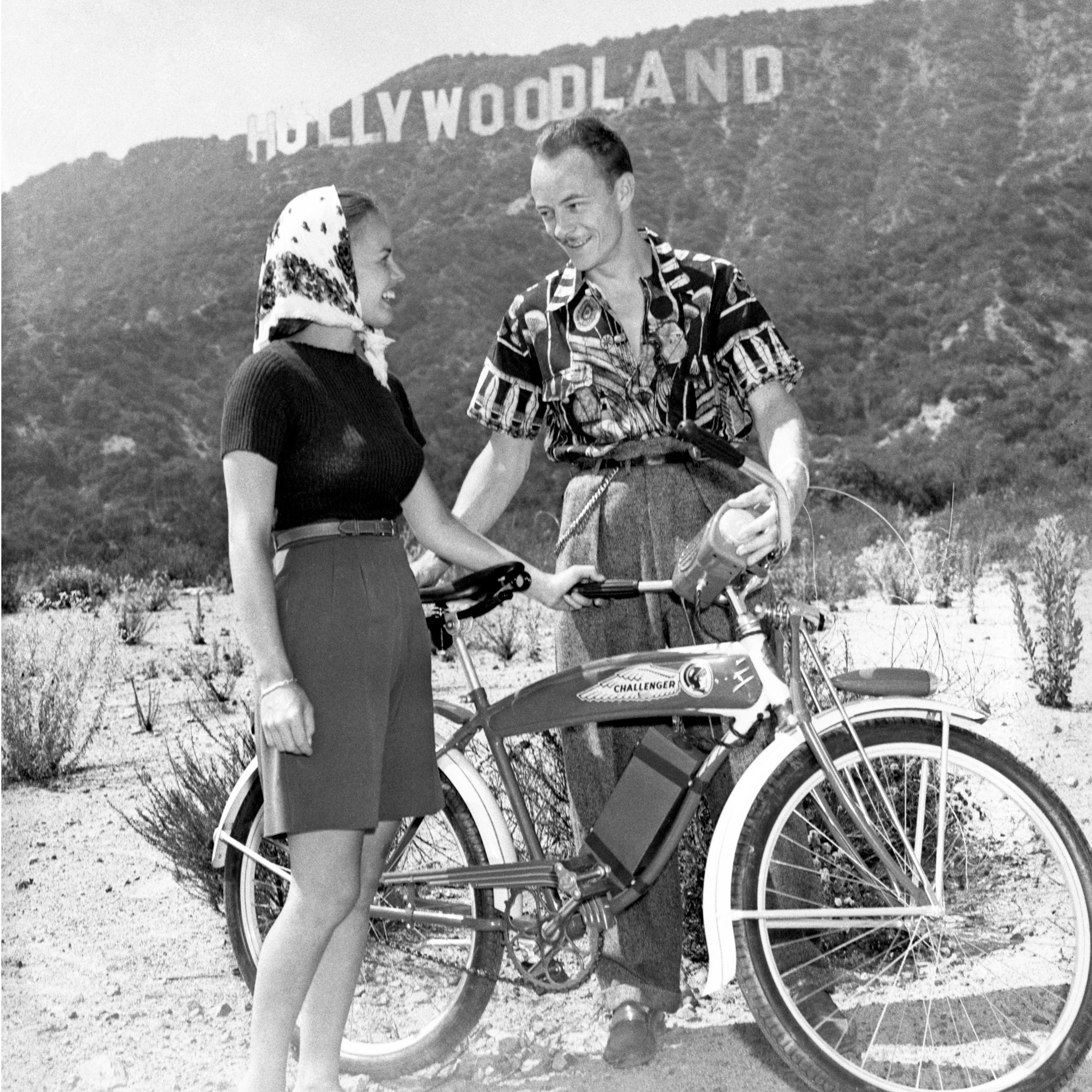 Les Tremayne aus der Sendung „First Nighter“ von CBS Radio und seine Frau (die ehemalige Eileen Palmer) mit ihren Fahrrädern in den Hollywood Hills, mit dem Hollywoodland-Schild im Hintergrund;  3. August 1940.