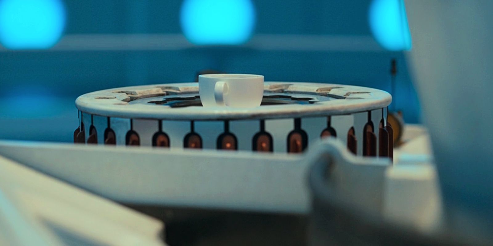 Eine Kaffeetasse steigt aus einem Zylinder im Bedienfeld der TARDIS. 