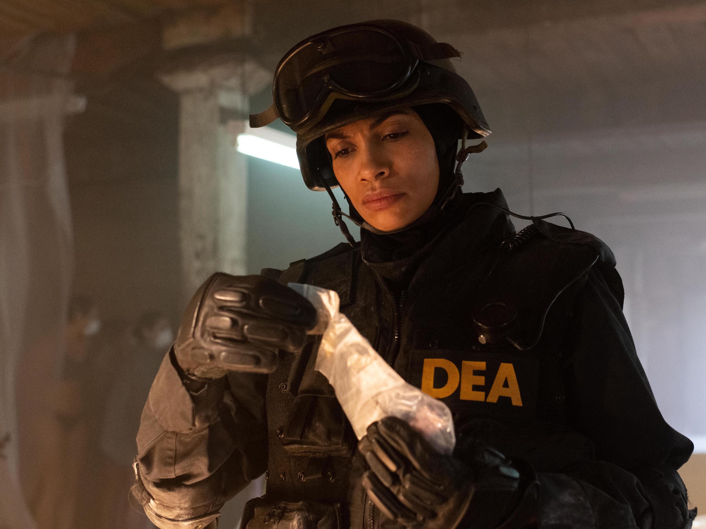 Ein DEA-Beamter, gespielt von Rosario Dawson, hält in Hulus „Dopesick“ eine Tüte Drogen in der Hand.