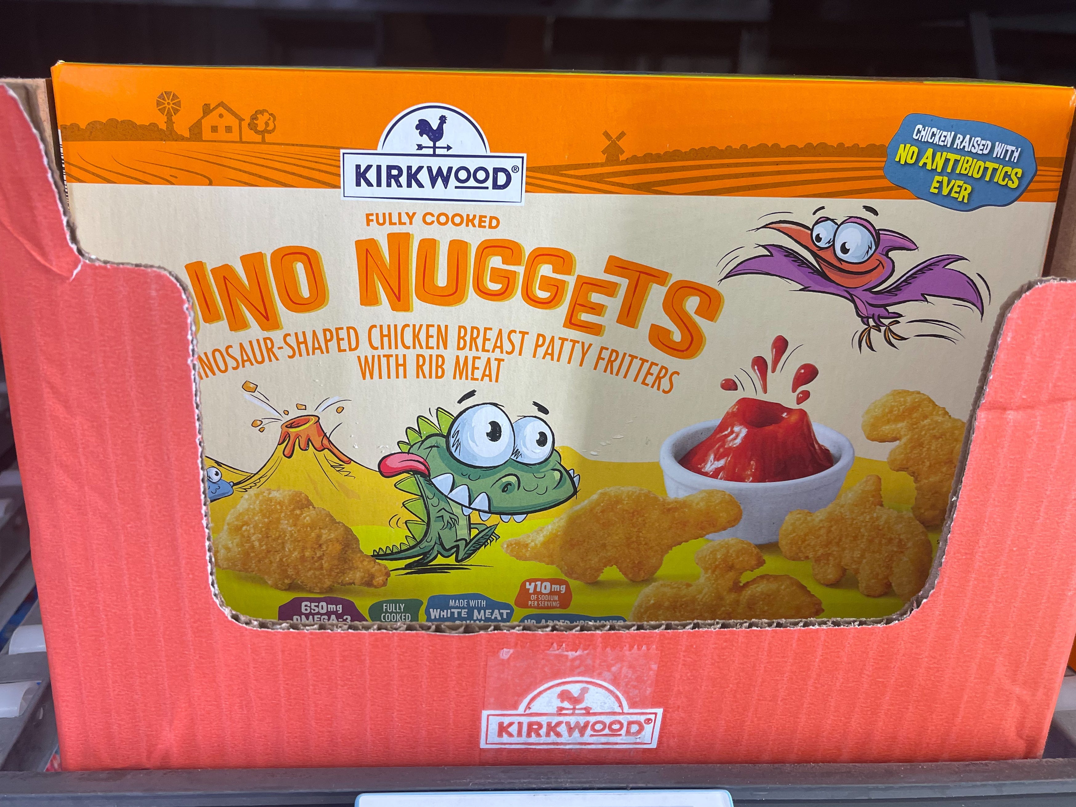 Schachtel mit „Dino Nuggets“-Text und Illustration eines Dinosauriers in einem Karton auf einem Regal