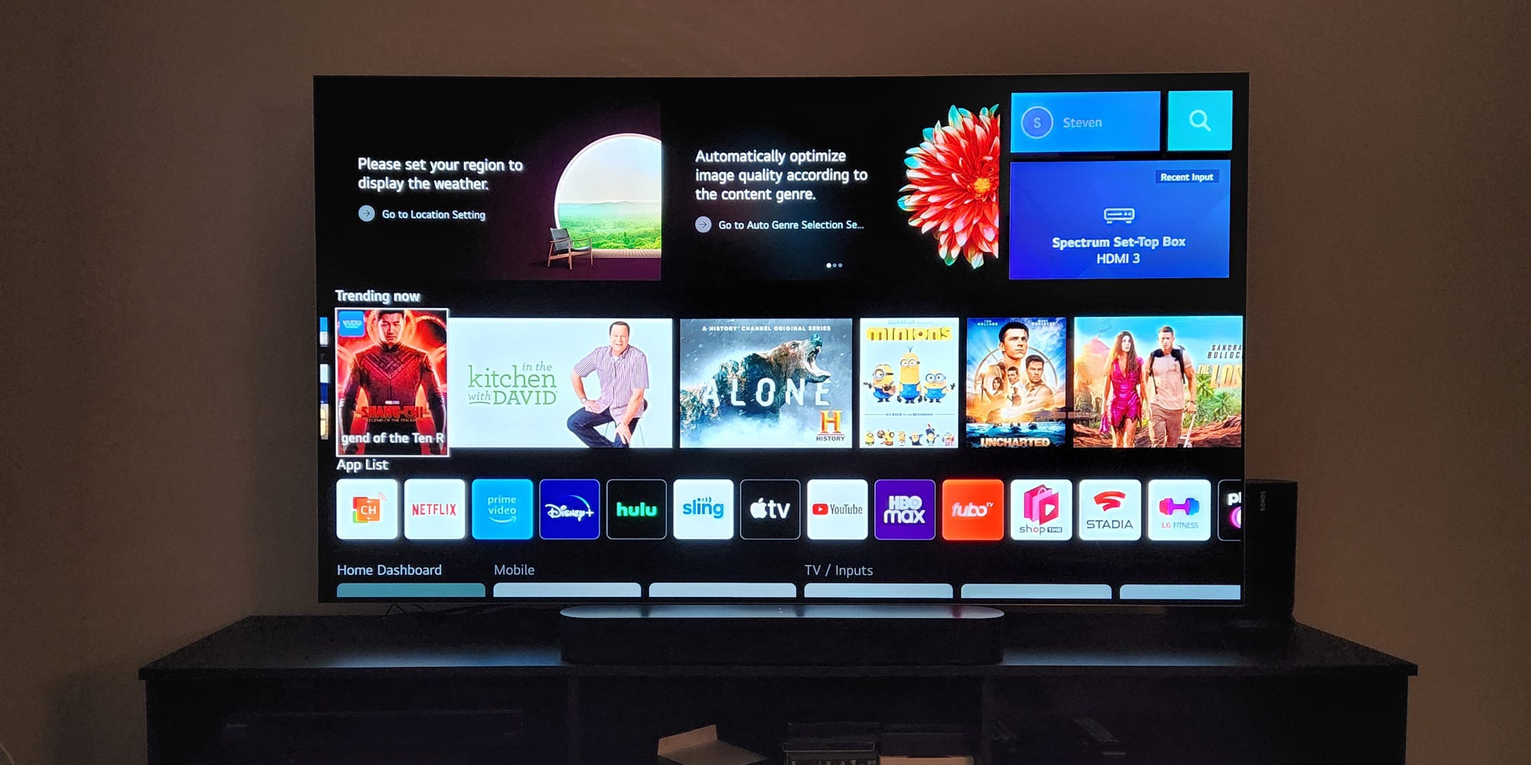 Das LG webOS-Menü abgebildet auf einem LG G2 OLED-Fernseher, der auf einer Unterhaltungskonsole ruht.