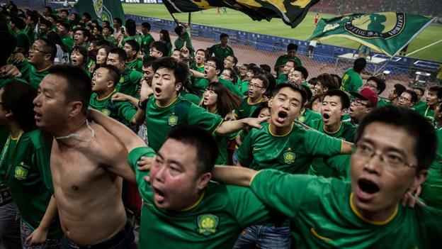 Fans von Beijing Guoan singen und springen während eines Spiels der chinesischen Super League mit dem Rücken zum Spielfeld