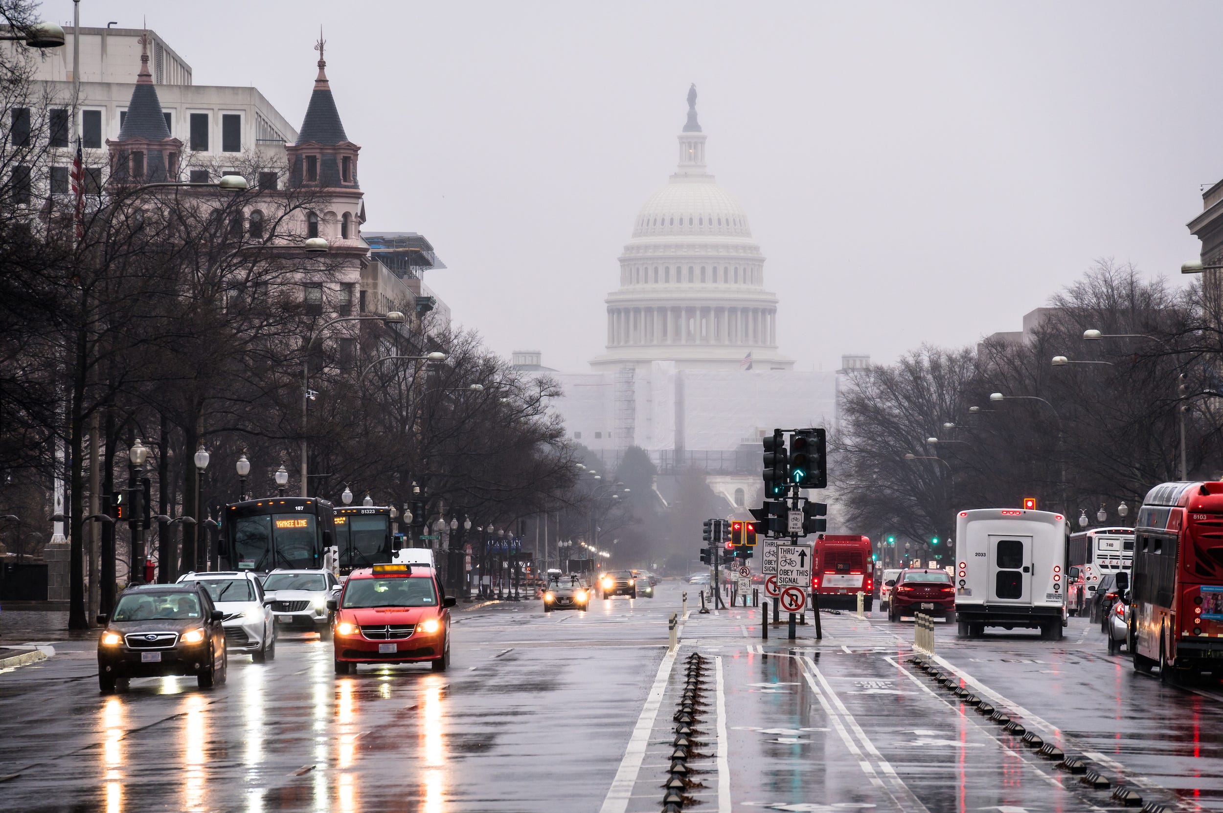 Belebte Straße an einem regnerischen Tag mit dem US-Kapitol im Hintergrund.