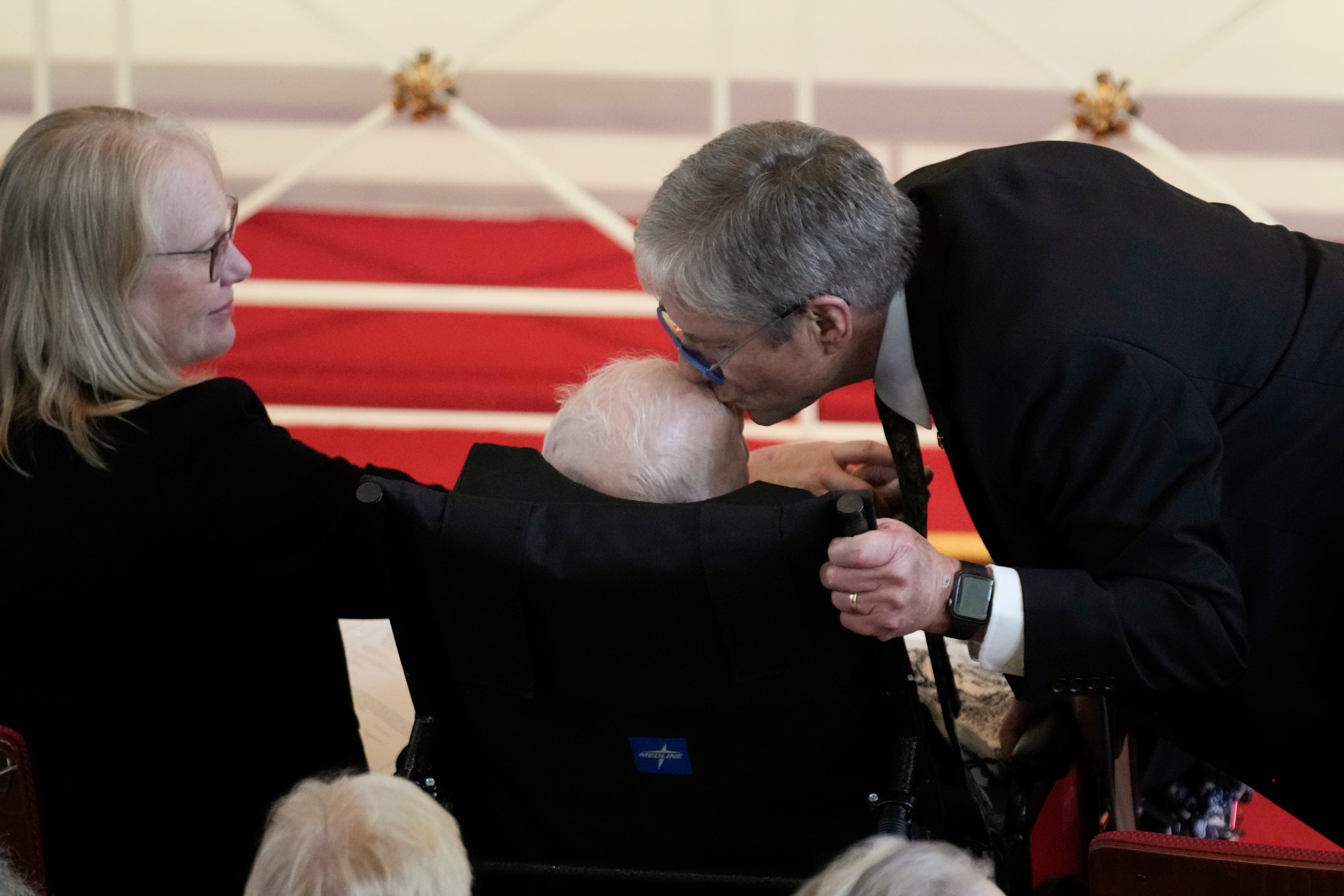 Ein Foto von James „Chip“ Carter, der seinen Vater, den ehemaligen Präsidenten Jimmy Carter, auf die Stirn küsst.