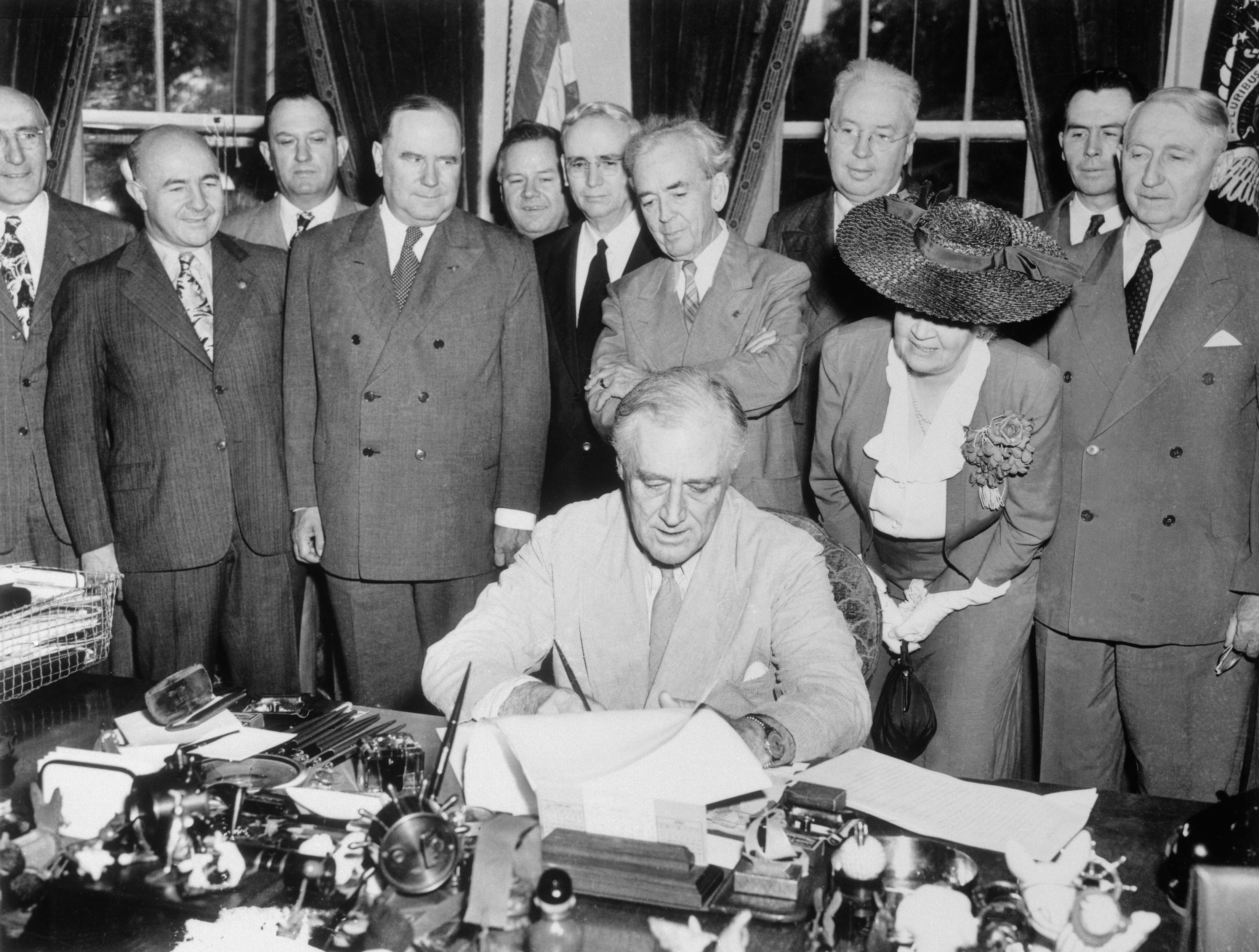 Präsident Franklin Roosevelt hat heute das GIB Bill of Rights unterzeichnet, das umfassende Vorteile für Veteranen des Zweiten Weltkriegs bietet.  An der Zeremonie nahmen Mitglieder des Senats und des Repräsentantenhauses sowie Mitglieder der American Legion und Veterans of Foreign Wars teil