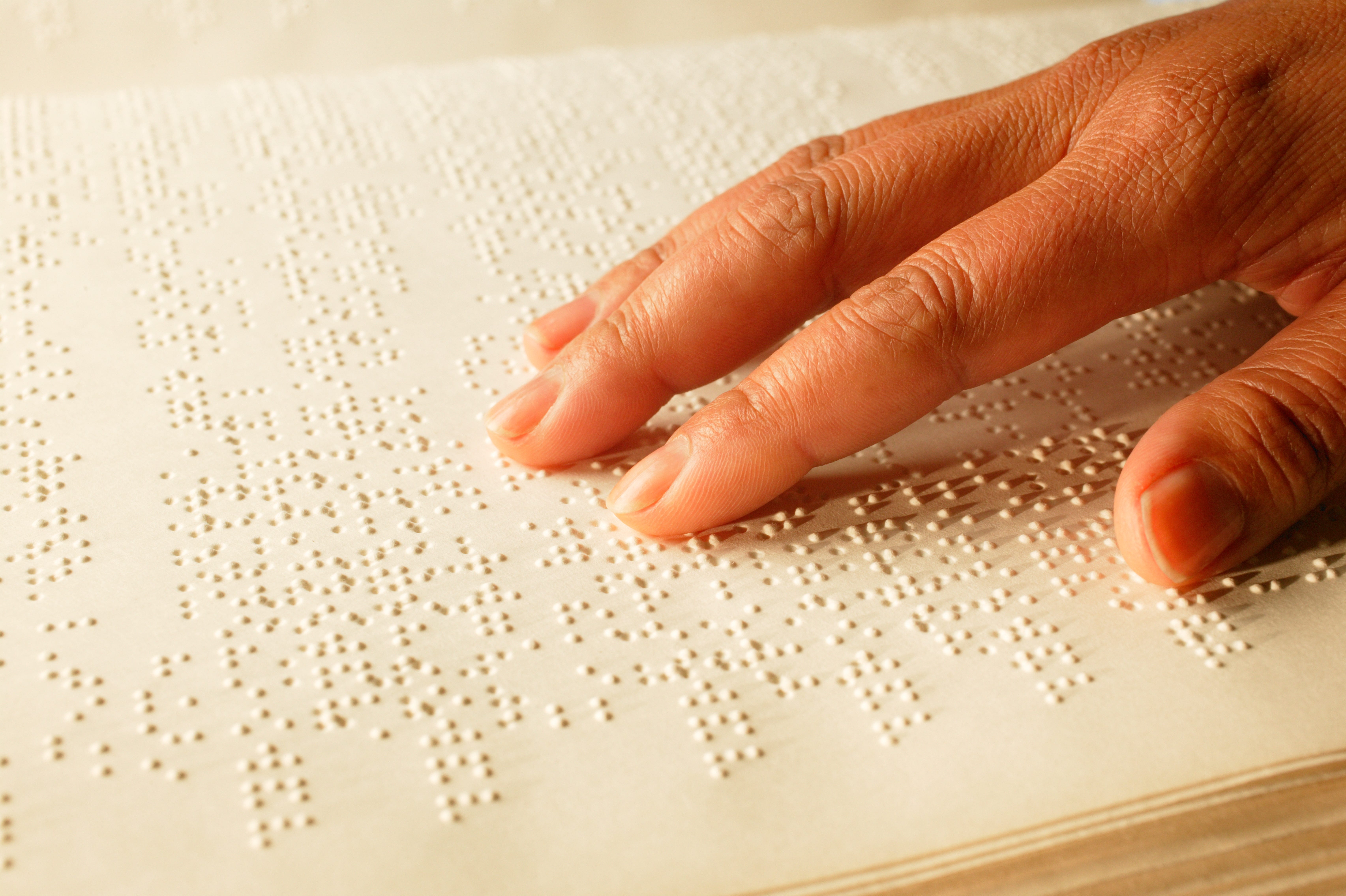 Hand auf Braille-Buch