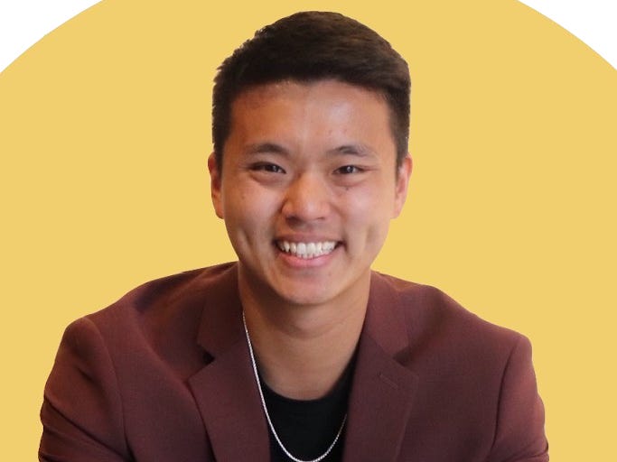 Eric Yu im Anzug vor gelbem Hintergrund.