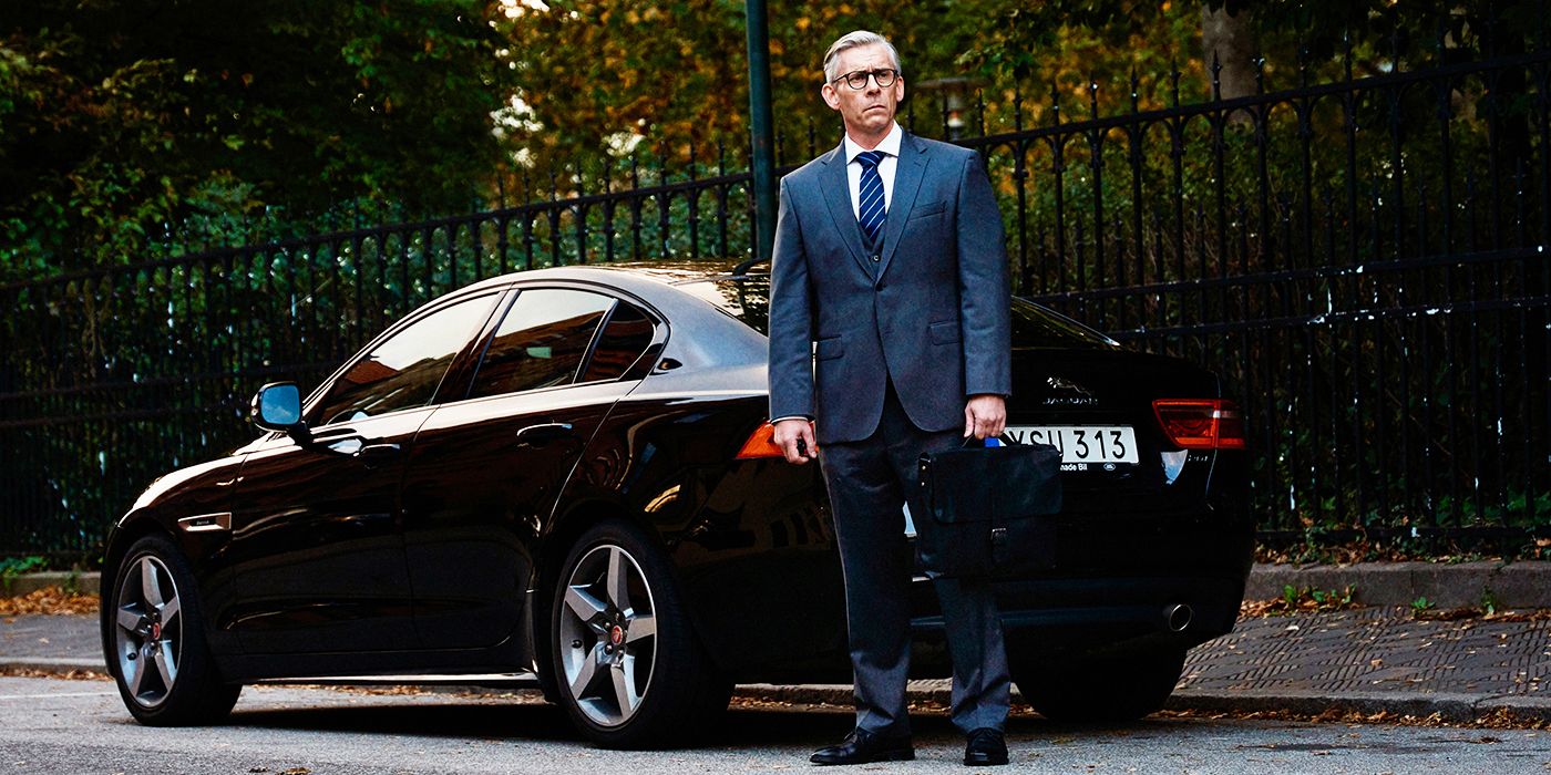   Håkan Bengtsson als Mikael, der in „Eine fast normale Familie“ neben einem Auto steht und ernst aussieht