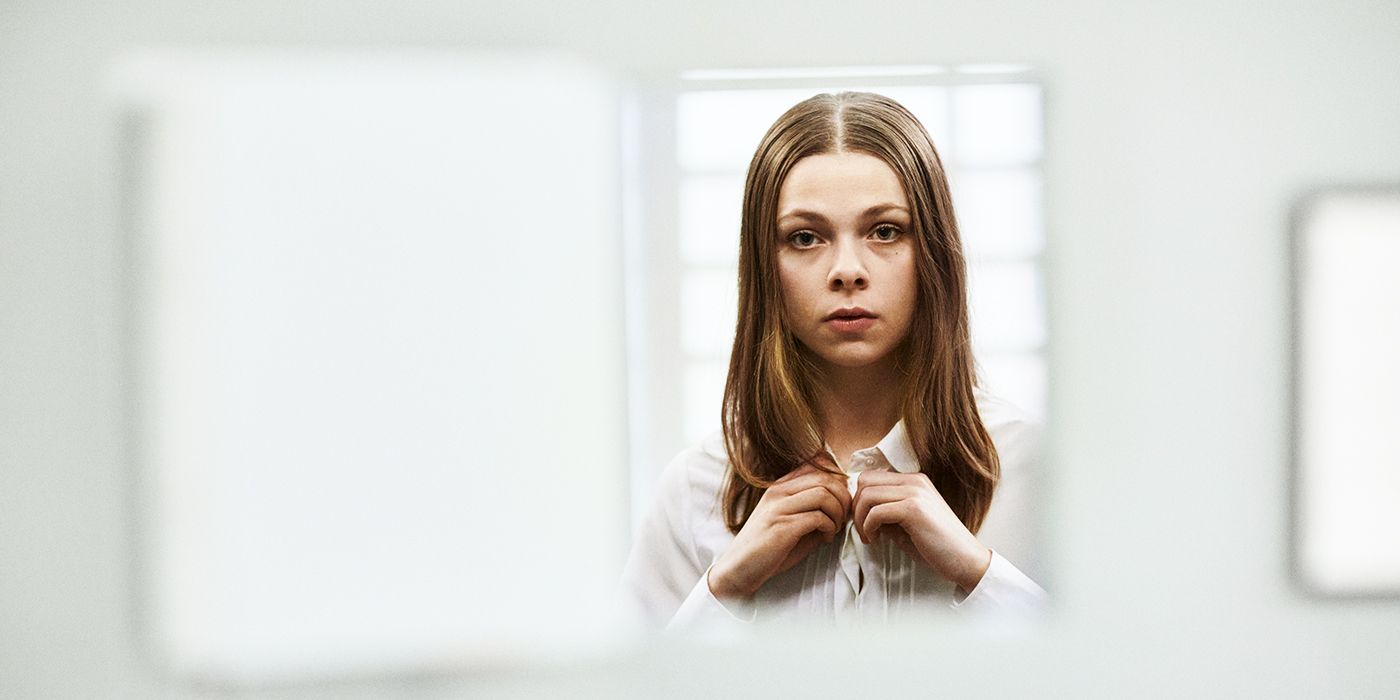 Alexandra Karlsson Tyrefors als Stella, die in „Eine fast normale Familie“ ernst aussieht und ihr Hemd zuknöpft