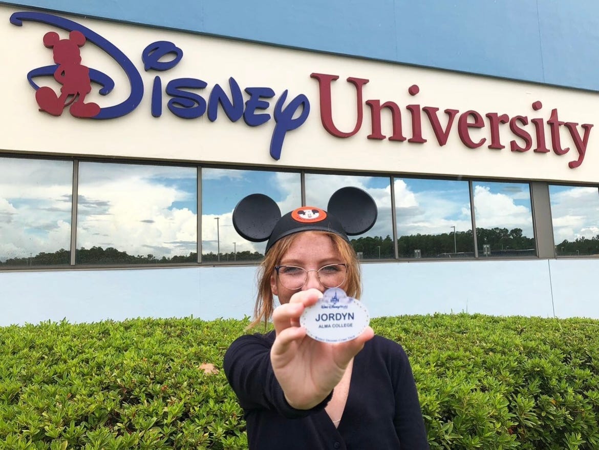 Jordan hält ihr Namensschild vor der Disney University in Disney World hoch