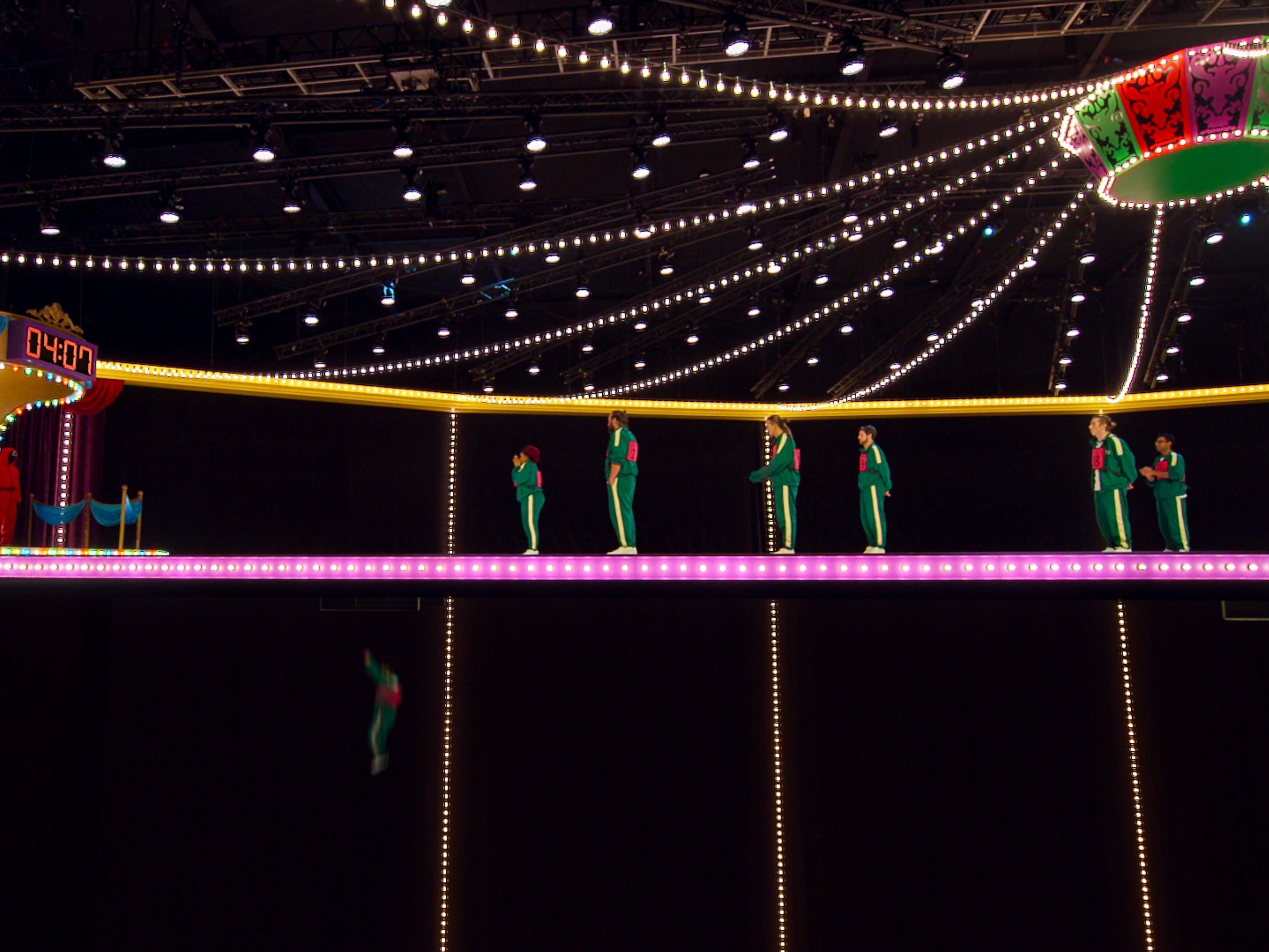 Die Glasbrücke in Squid Game ist die Herausforderung, eine hängende, hell erleuchtete Brücke in einem Zirkuszelt-ähnlichen Set
