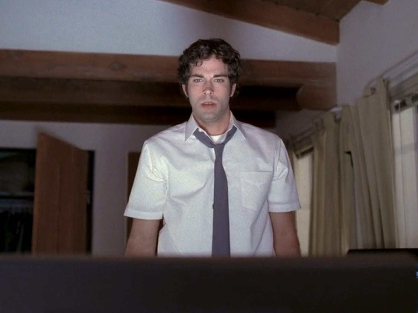 Zachary Levi in ​​weißem Hemd und grauer Krawatte auf Chuck, Blick auf einen Computerbildschirm