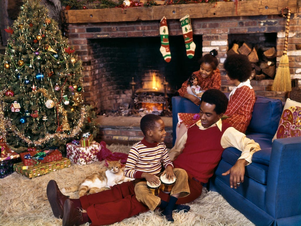 Eine Familie sitzt 1975 an einem Kamin und einem Weihnachtsbaum