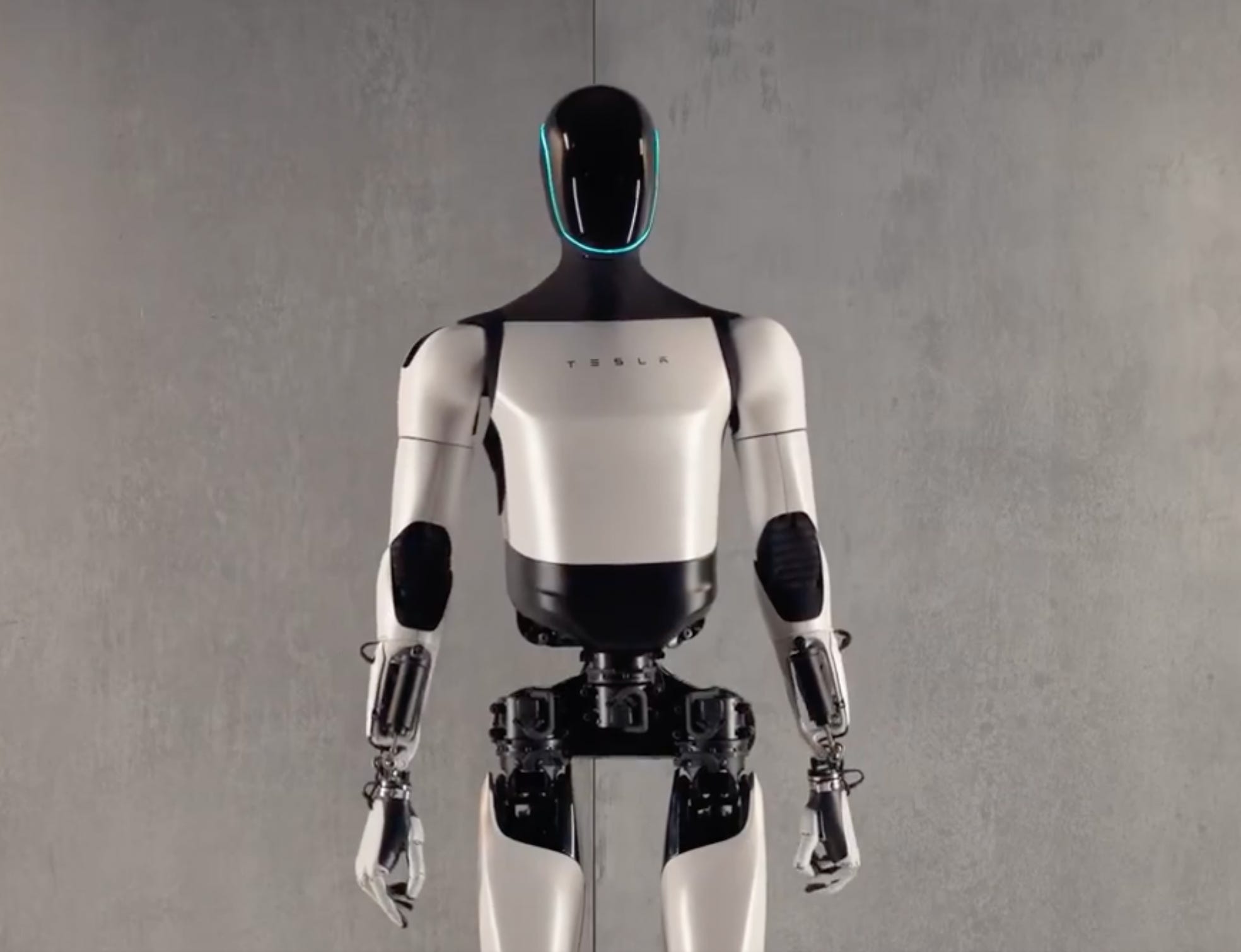 Foto von Teslas humanoidem Roboter namens Optimus.  Es hat weiße Körperteile und einen komplett schwarzen Kopf mit blauem Licht