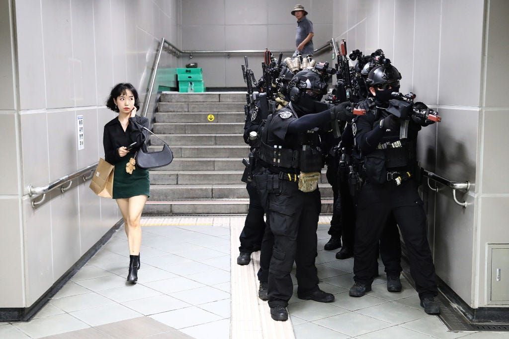 Eine Frau geht vorbei, während südkoreanische Soldaten an einer Anti-Chemikalien- und Anti-Terror-Übung teilnehmen