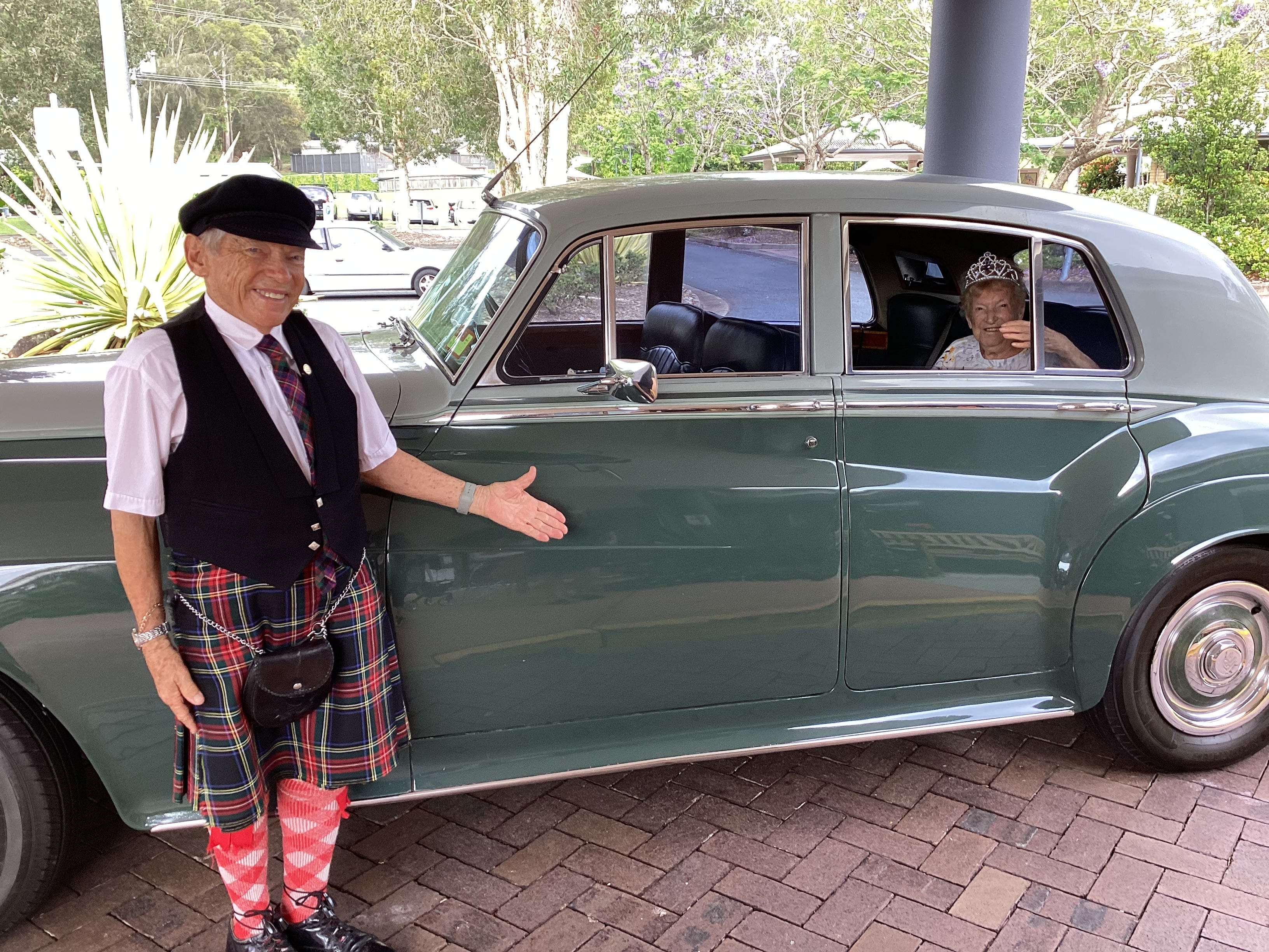 Katie MacRae in einem alten Auto mit Chauffeur an ihrem 106. Geburtstag.