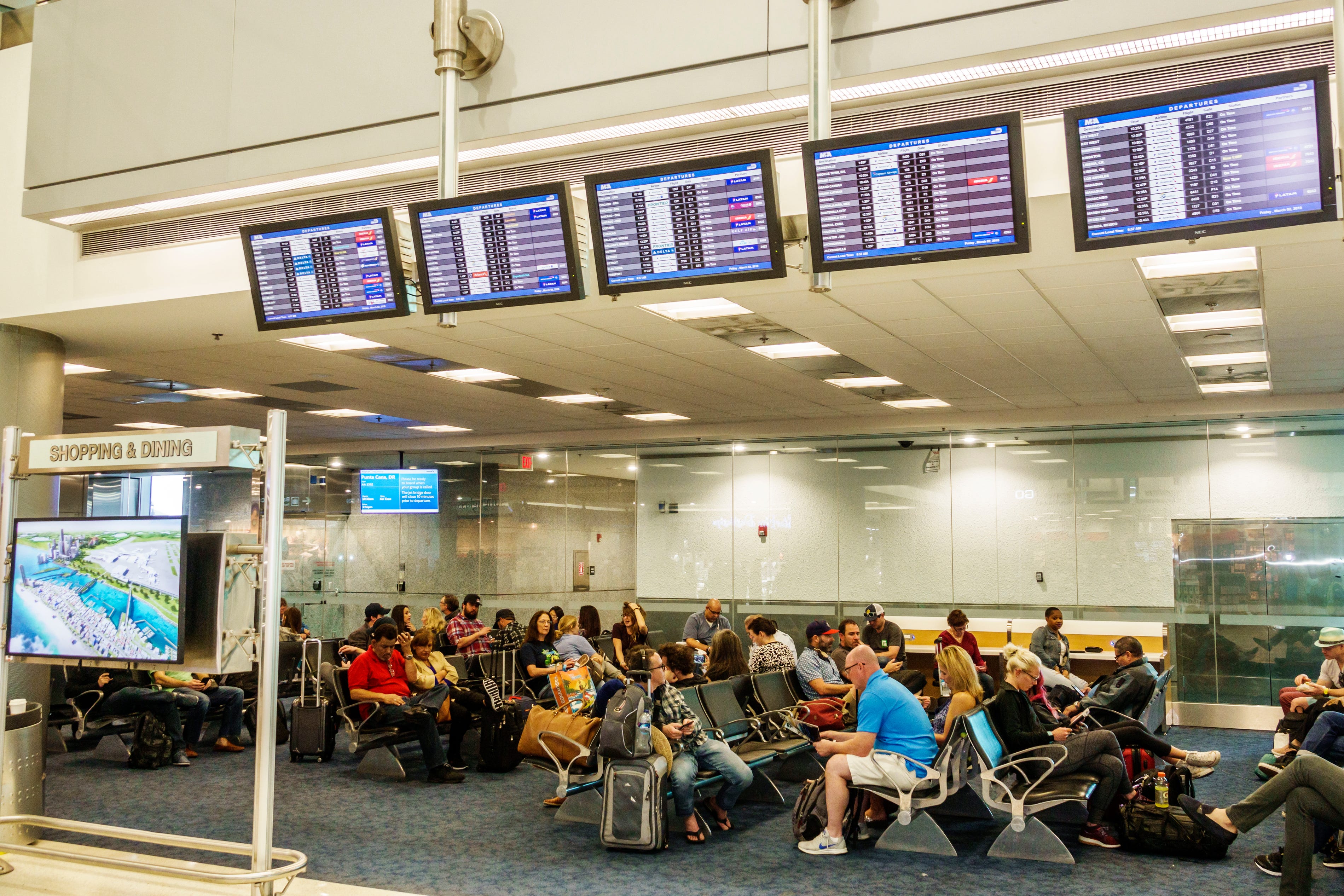 Ein überfüllter Gate-Bereich mit einer Fluginformationsanzeige am Miami International Airport in Florida am 1. März 2018.