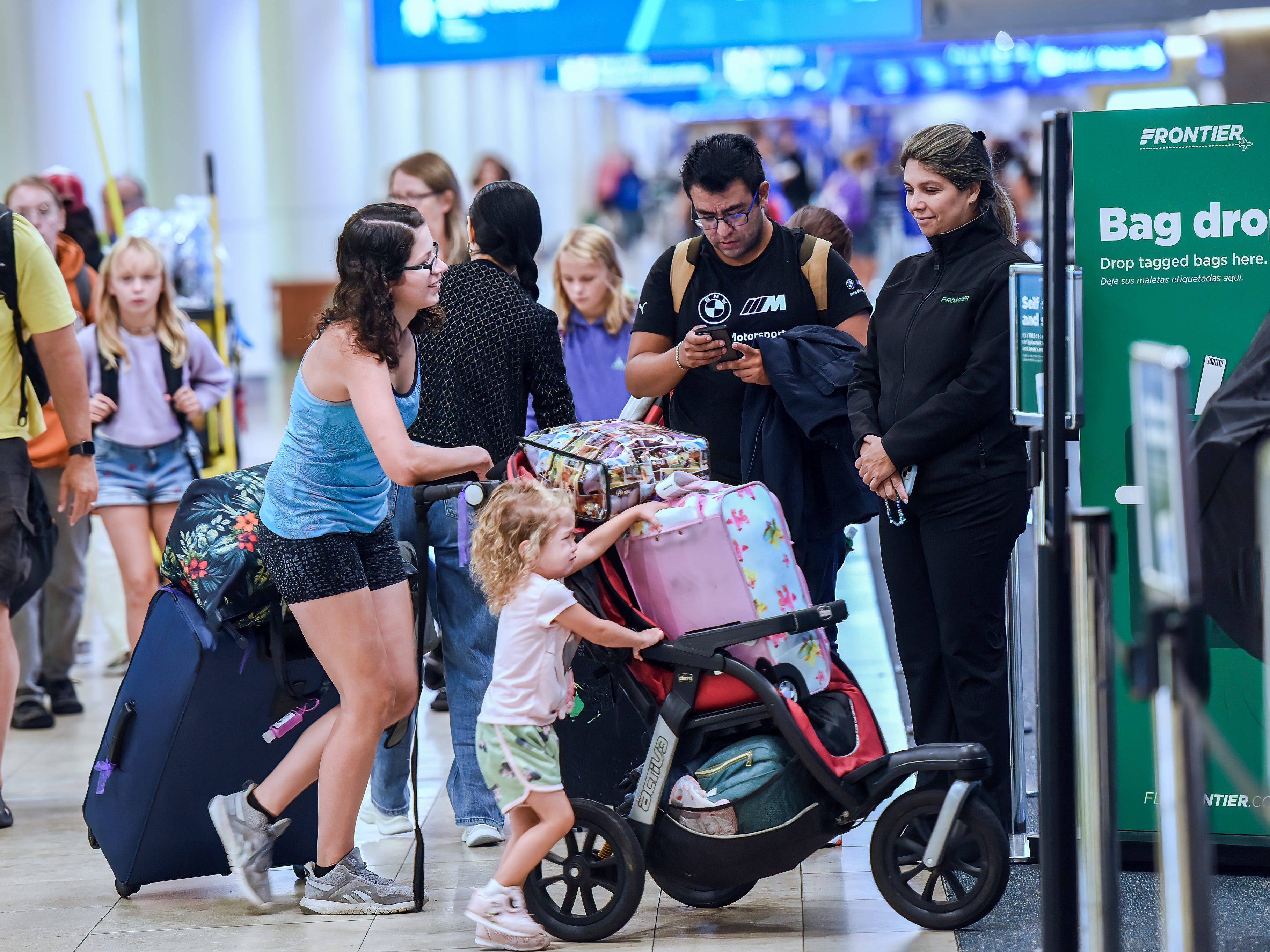 Während des geschäftigen Feiertagswochenendes Labor Day in Orlando 2023 warten Reisende an einem Frontier-Ticketschalter am Orlando International Airport darauf, für ihren Flug einzuchecken.