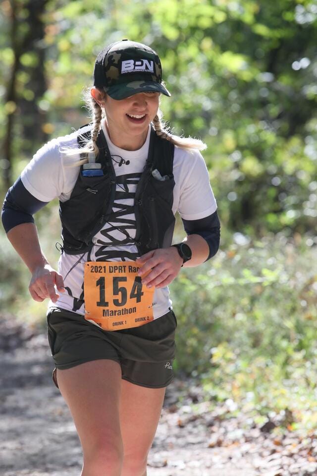 Katina DeJarnett in Sportkleidung und Startnummer bei einem Trail-Marathon.