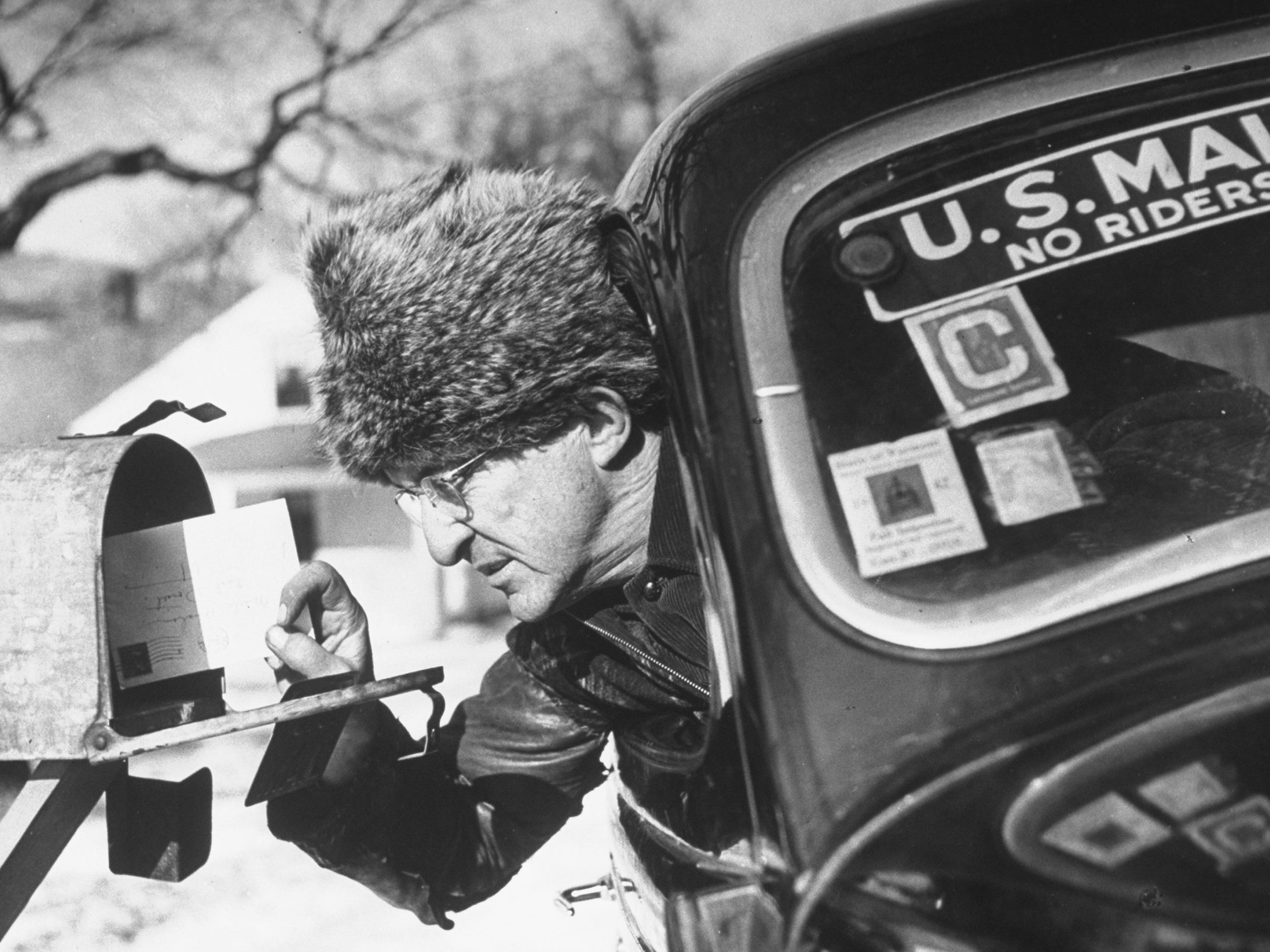 Ein Postangestellter trägt 1942 eine Pelzmütze
