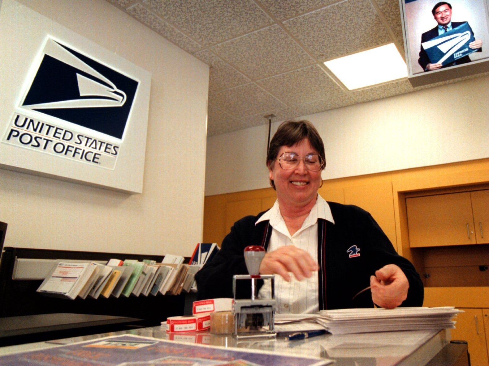 Ein Postangestellter trägt 1998 eine Strickjacke