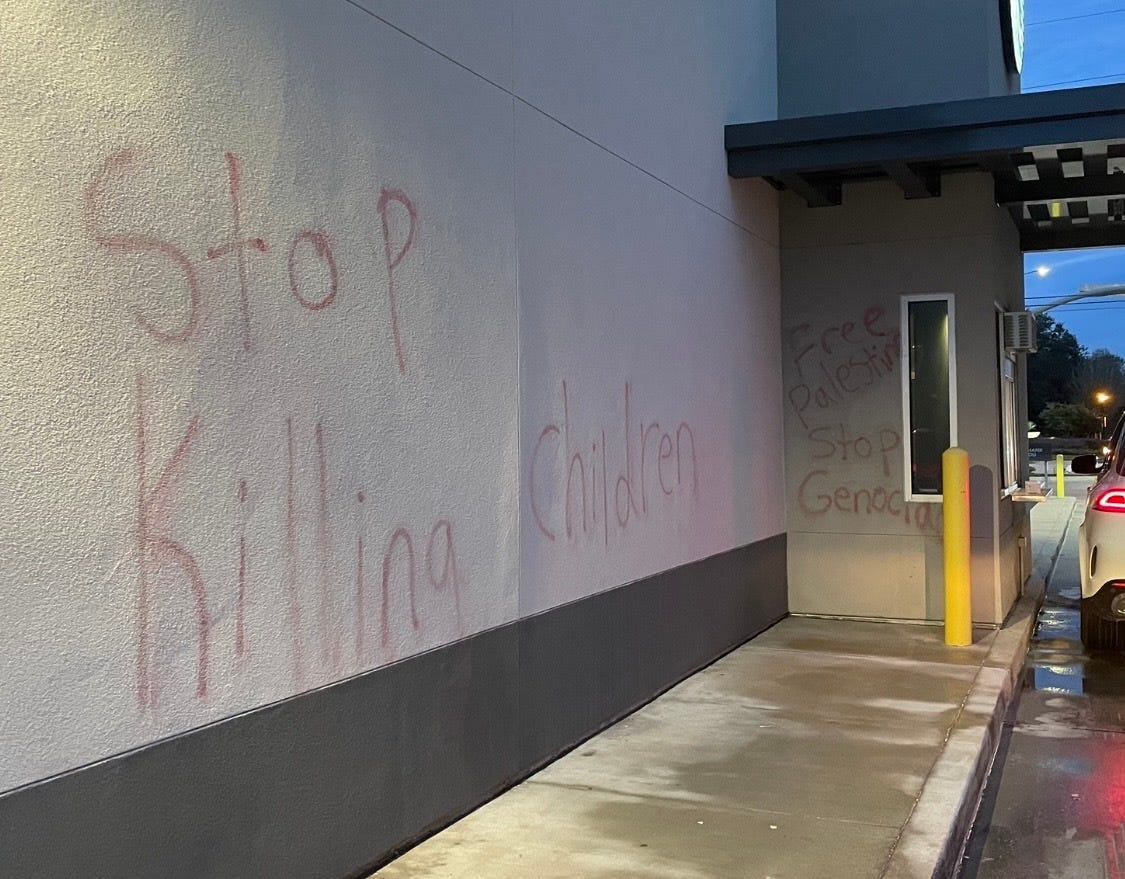 Die Worte „Hört auf, Kinder zu töten“, „Befreit Palästina“ und „Stoppt den Völkermord“ waren an die Wände außerhalb dieser Starbucks-Durchfahrtsstraße gemalt.