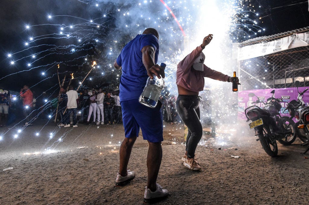 Während der „Adoraciones al Nino Dios“-Feierlichkeiten in Quinamayo tanzen Menschen, während ein Feuerwerk explodiert
