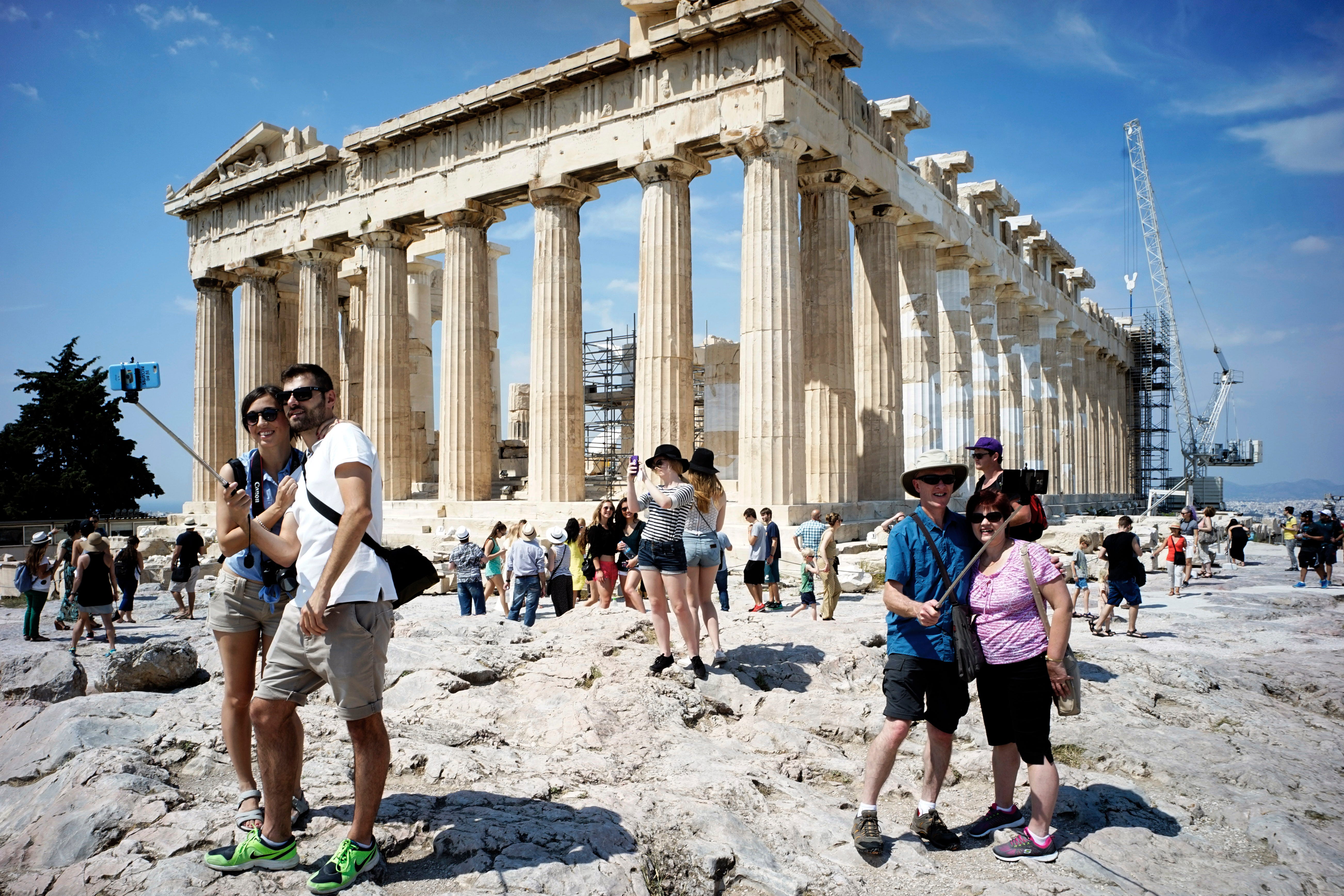 Touristen besuchen den antiken Akropolis-Hügel