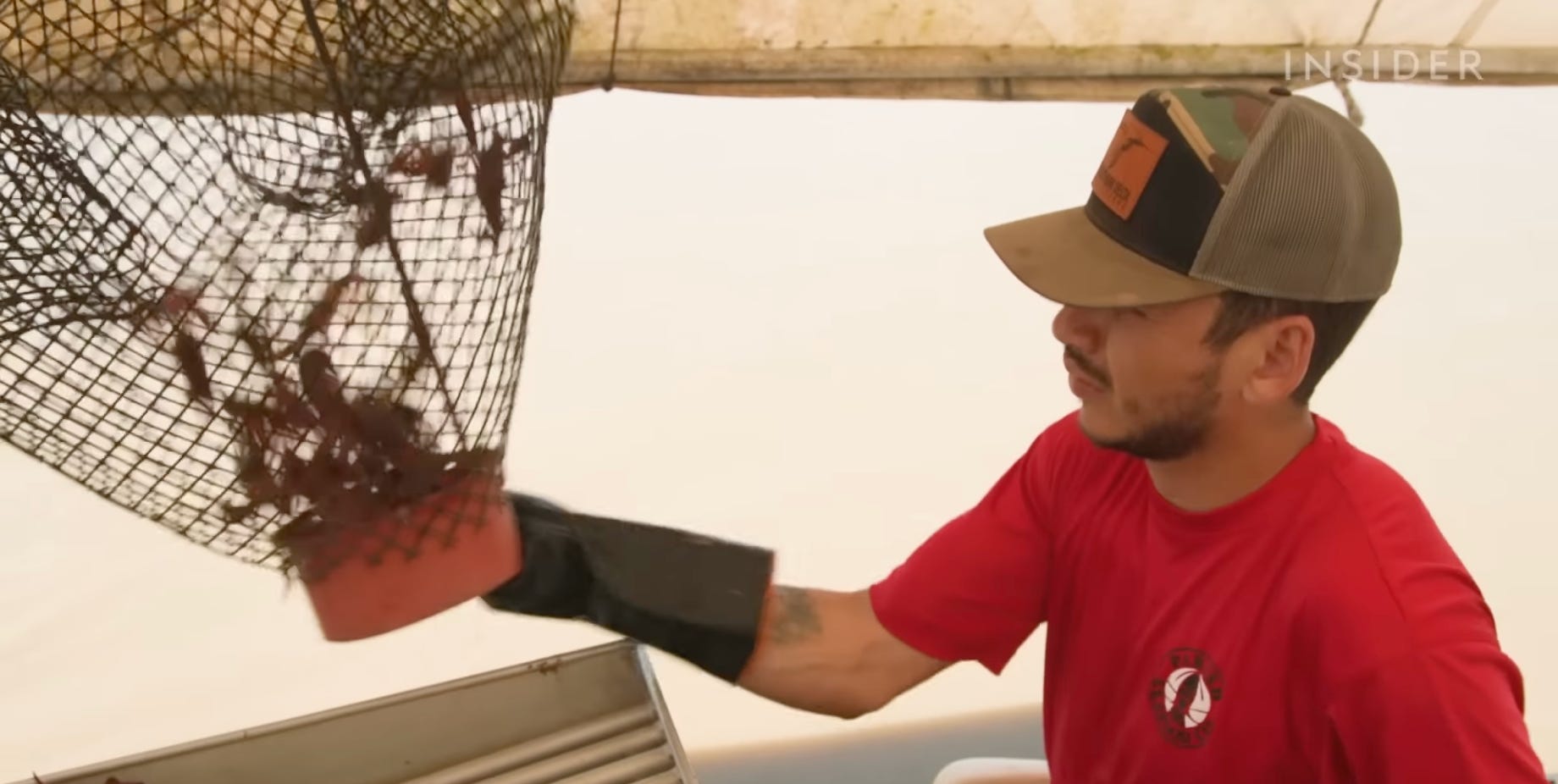 Ein Parish Seafood Wholesale-Besteller wirft Langusten aus einer Falle in sein Boot, das mit Fußpedalen gesteuert wird.