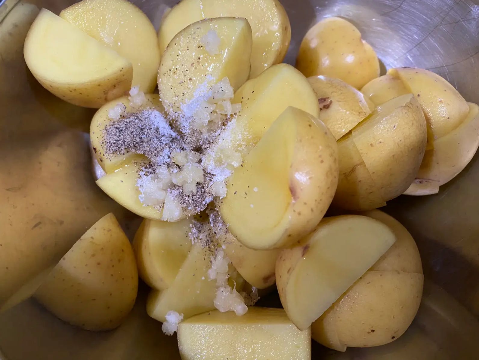 Kartoffeln, Öl und Gewürze in eine Rührschüssel geben
