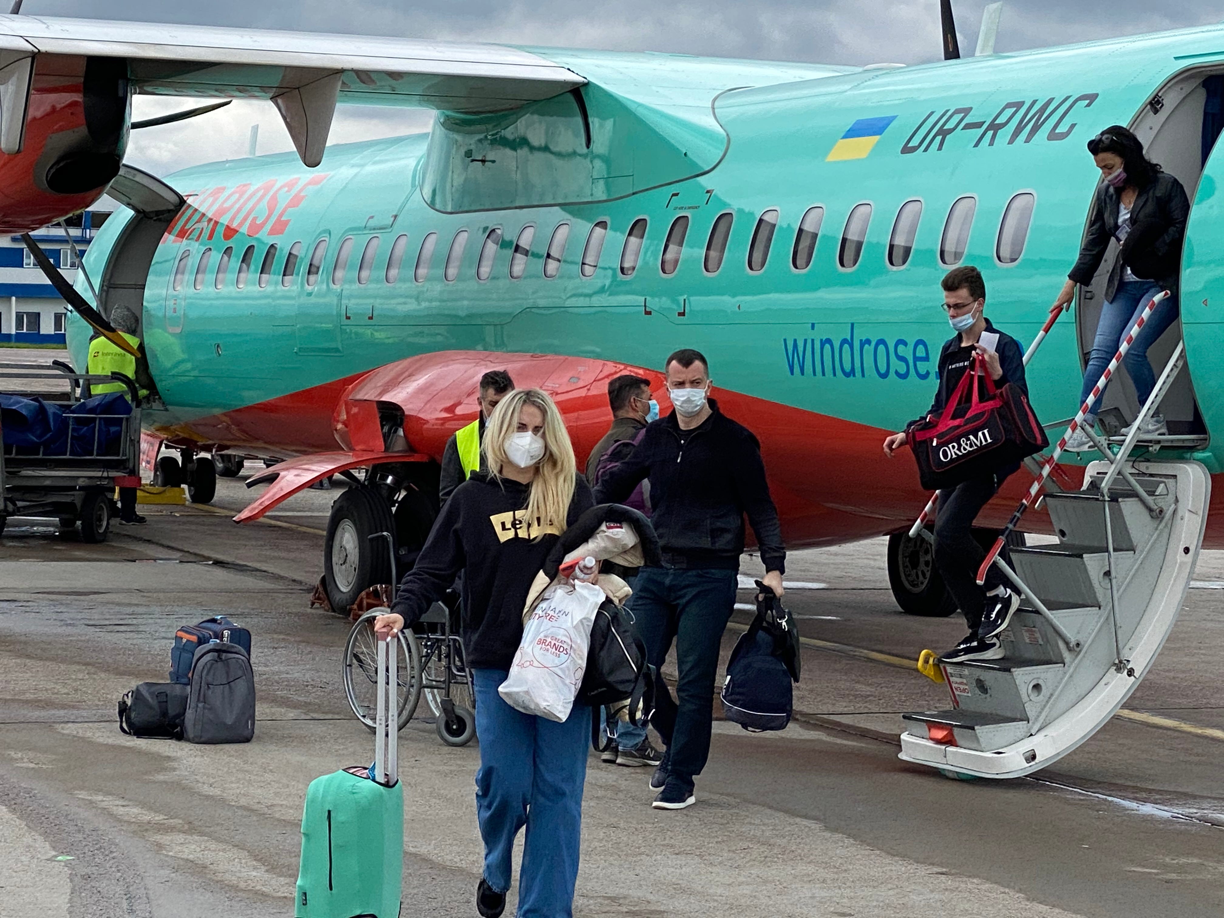 Passagiere mit Masken beim Aussteigen aus einem Windrose ATR im Jahr 2019.