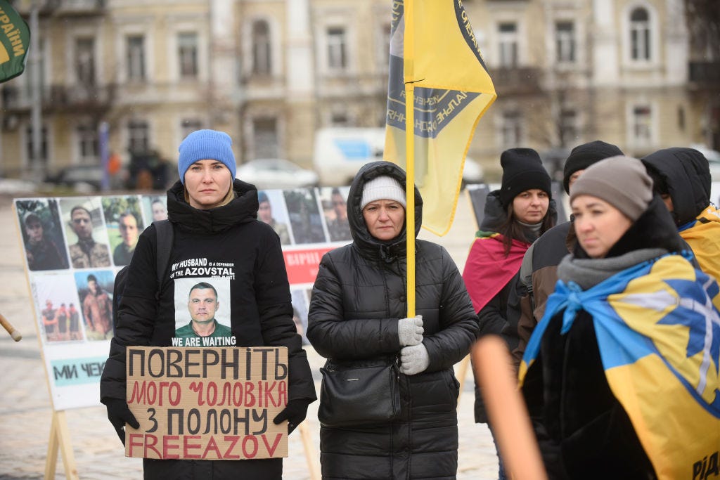 Demonstranten halten in Kiew Schilder und Fahnen hoch
