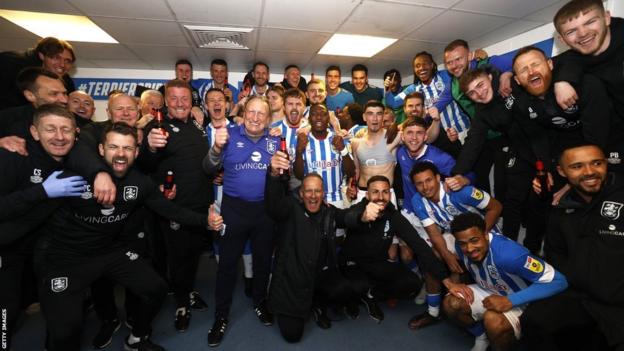 Spieler und Mitarbeiter von Huddersfield Town feiern in der Umkleidekabine