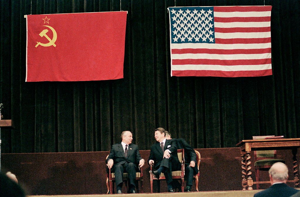 Im Mittelpunkt, sowohl im Internationalen Pressezentrum als auch im Weltgeschehen, lächeln der sowjetische Staatschef Michail Gorbatschow und US-Präsident Ronald Reagan während der abschließenden Gipfelzeremonie.