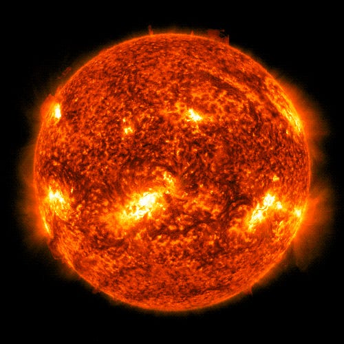 Die volle Sonnenscheibe brodelt in tieforangefarbenem Plasma, das mit hellen Flecken übersät ist, und plötzlich erscheint an einem Punkt oben links auf der Sonne ein heller Blitz, gefolgt von einem Ausbruch orangefarbener Ranken, die in den Weltraum schießen