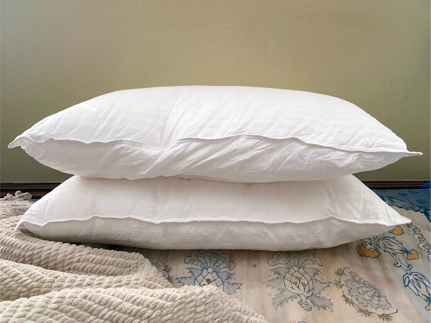 Zwei weiße Beckham Hotel-Kissen liegen flach übereinander auf einem Bett.
