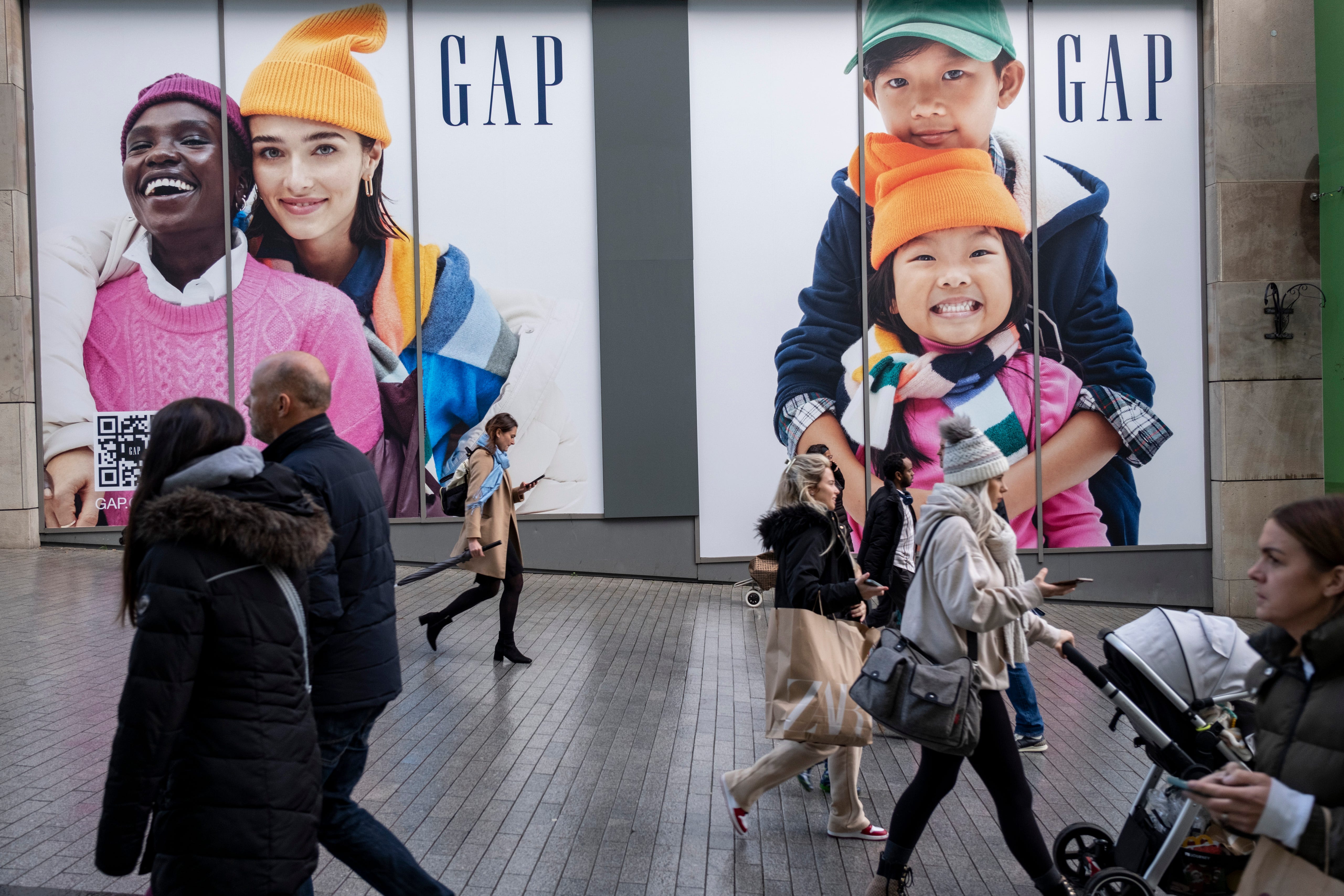 Käufer laufen an Gap-Werbung in Birmingham, England, vorbei.